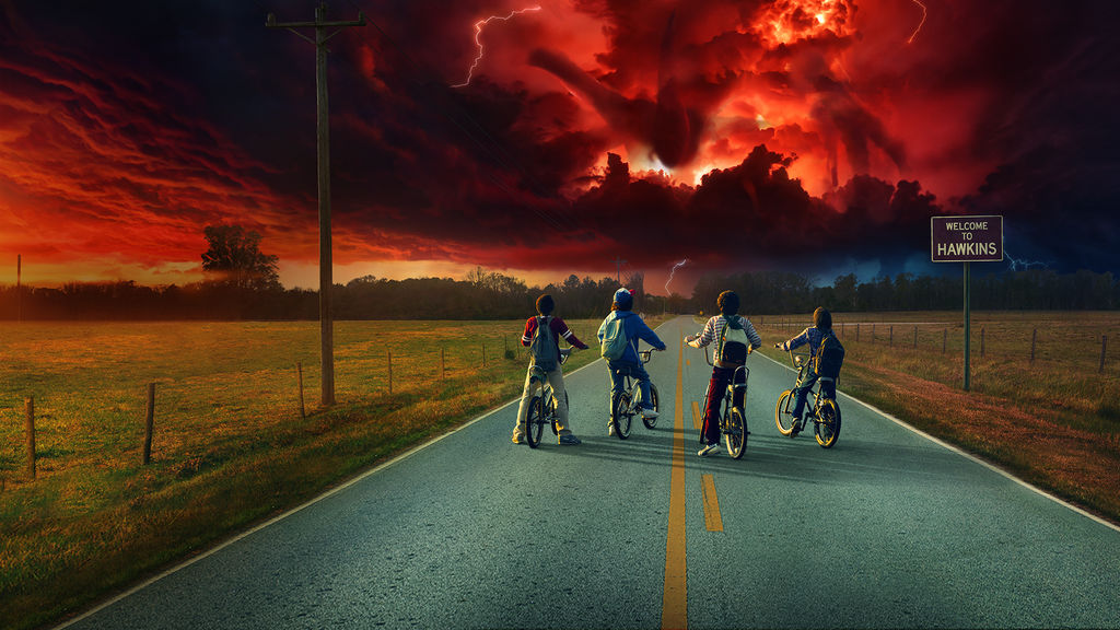 Four boys on bicycles staring at an ominous sunset.