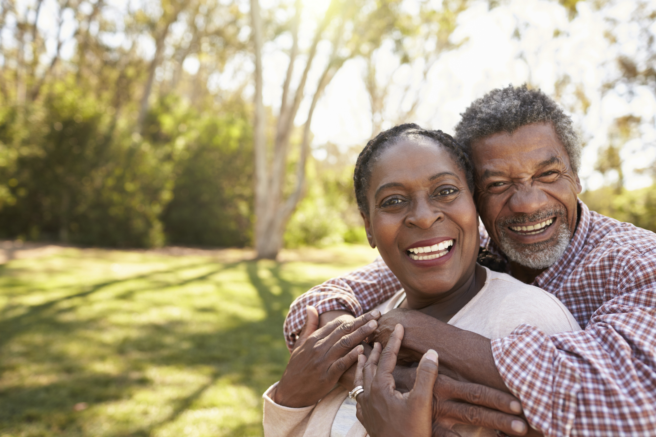 Smiling older man and woman embracing outdoors