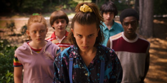 A teen girl staring intently while four friends look on.