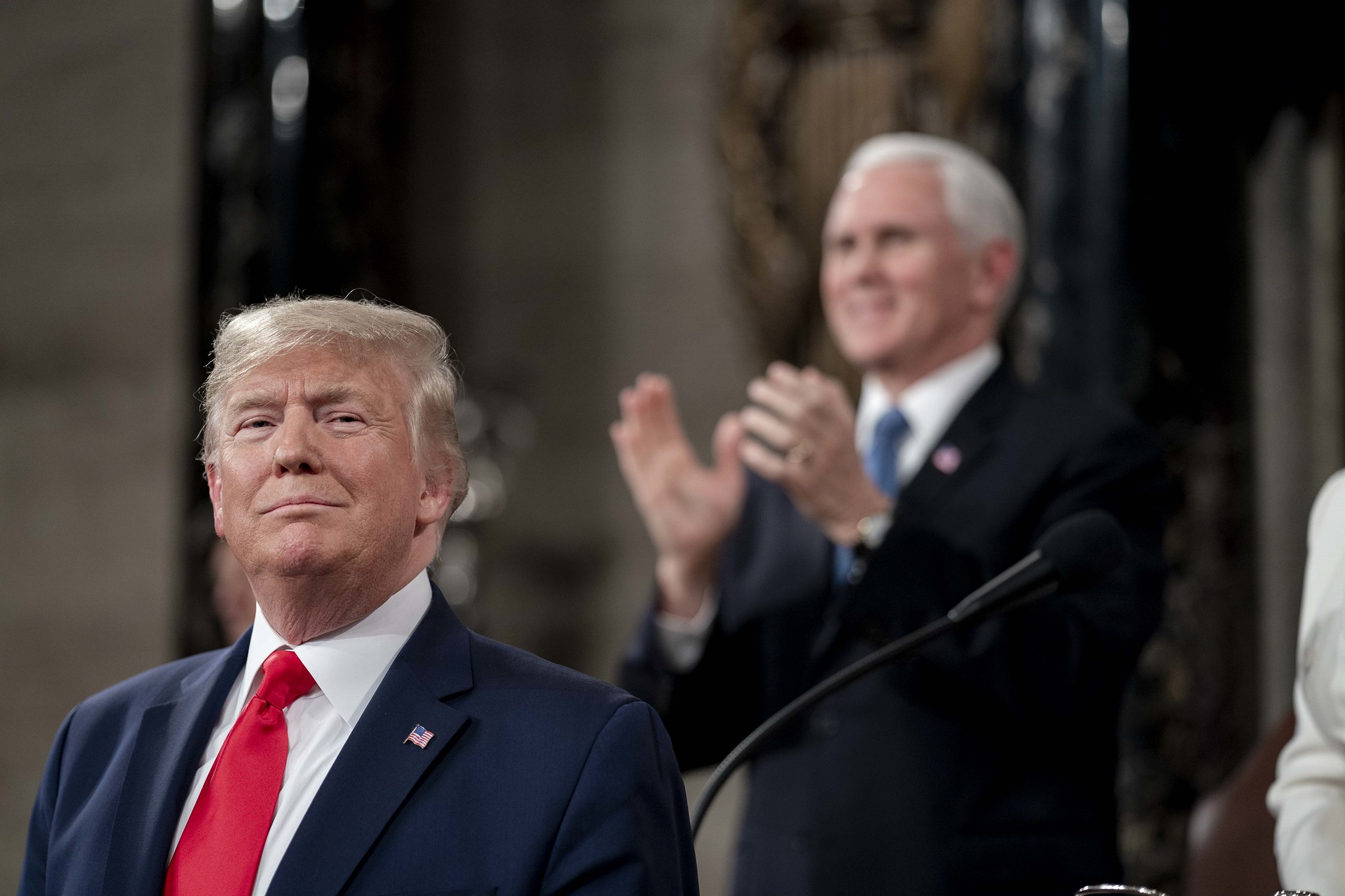 President Trump giving remarks during his State of the Union address as Vice President Pence applauds in the background.