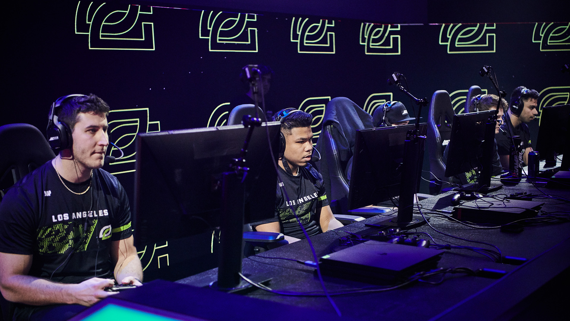 Esports players sitting in front of computers and wearing headsets.