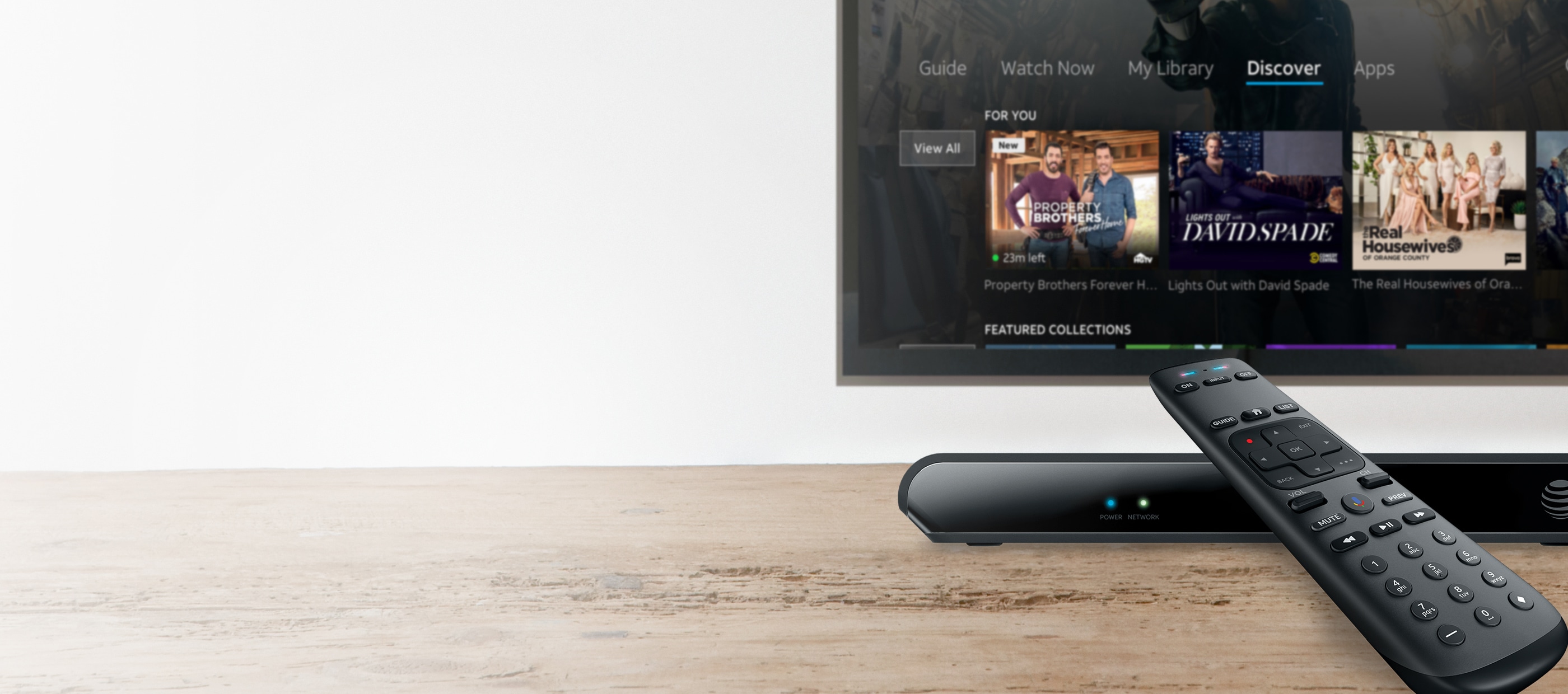 The AT&T TV set-top box and remote on a table, and the homescreen displayed on a television.