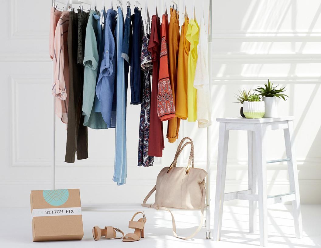 A closet with Stitch Fix clothes and a Stitch Fix box at the bottom.