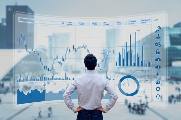 Finance trade manager analysing stock market indicators for best investment strategy, financial data and charts with business buildings in background.