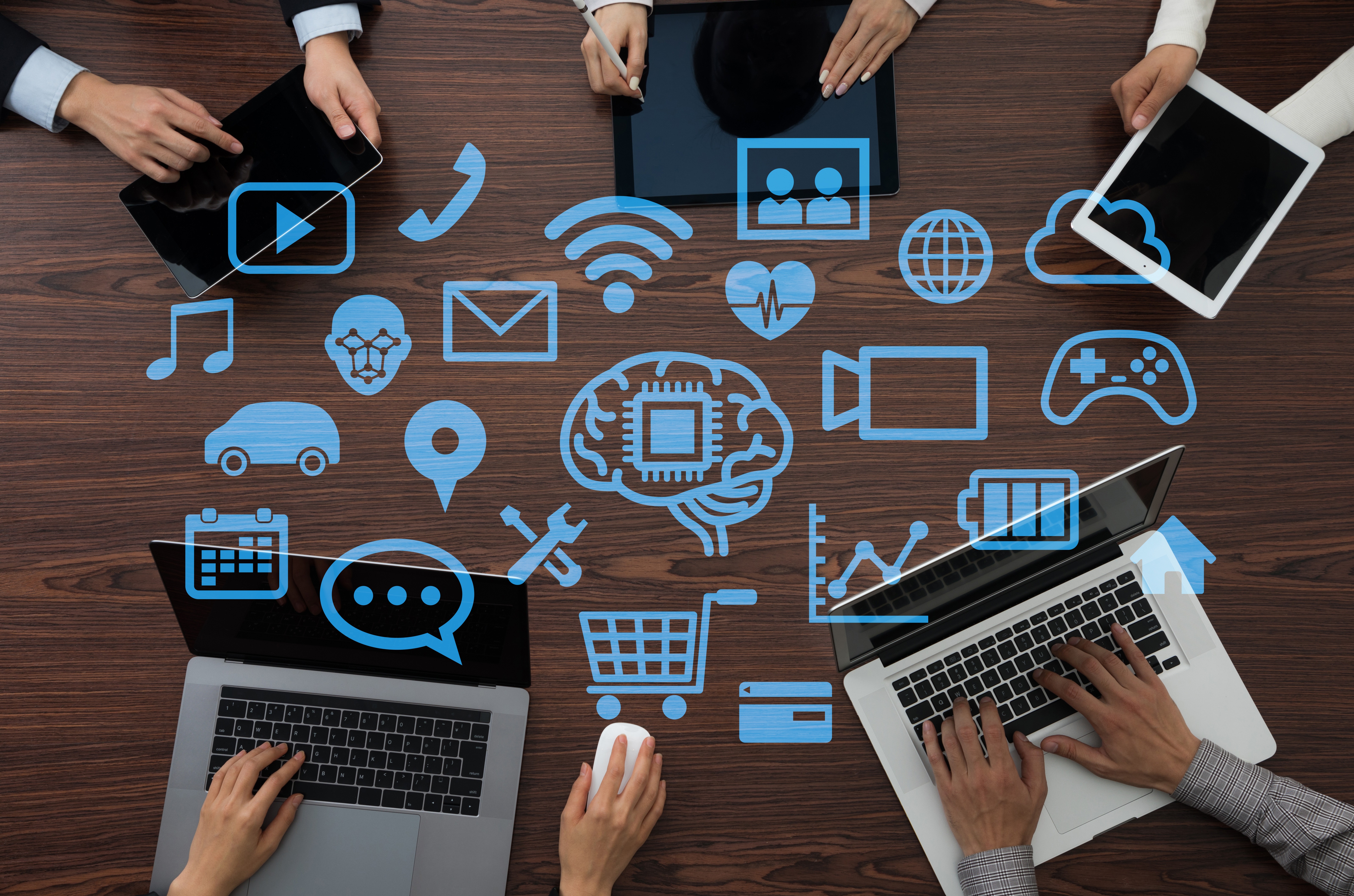 People working on different devices around a table.