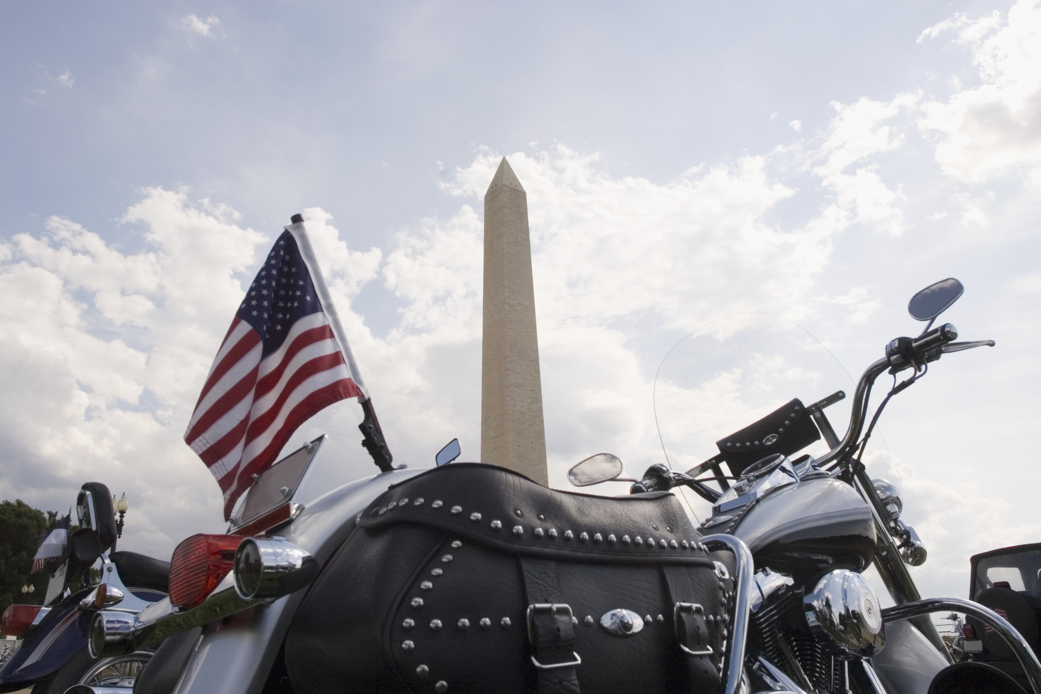 A motorcycle with an American flag parked in front of the Washington Monument