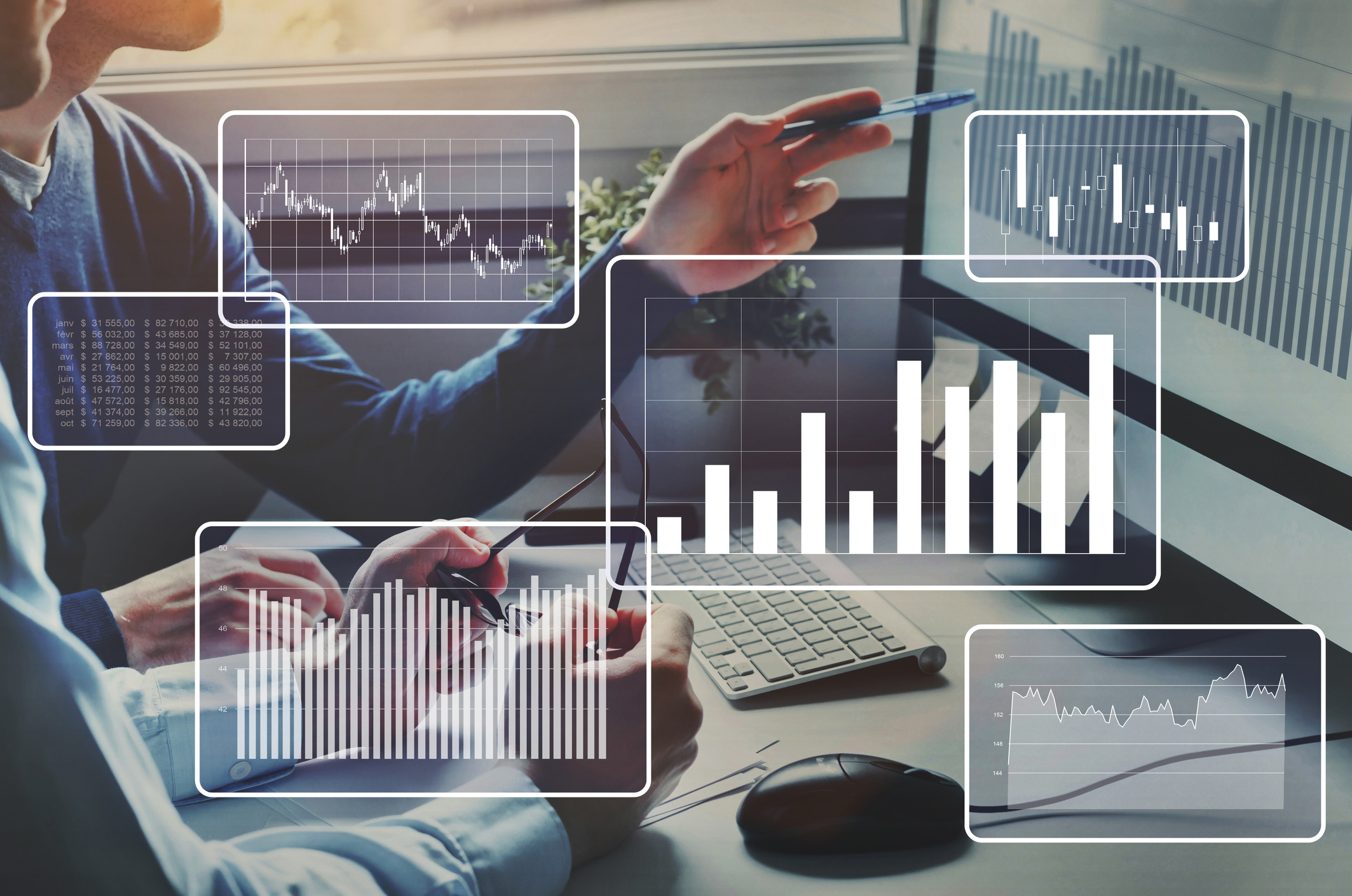 Two people working together at a computer with data analytics and charts