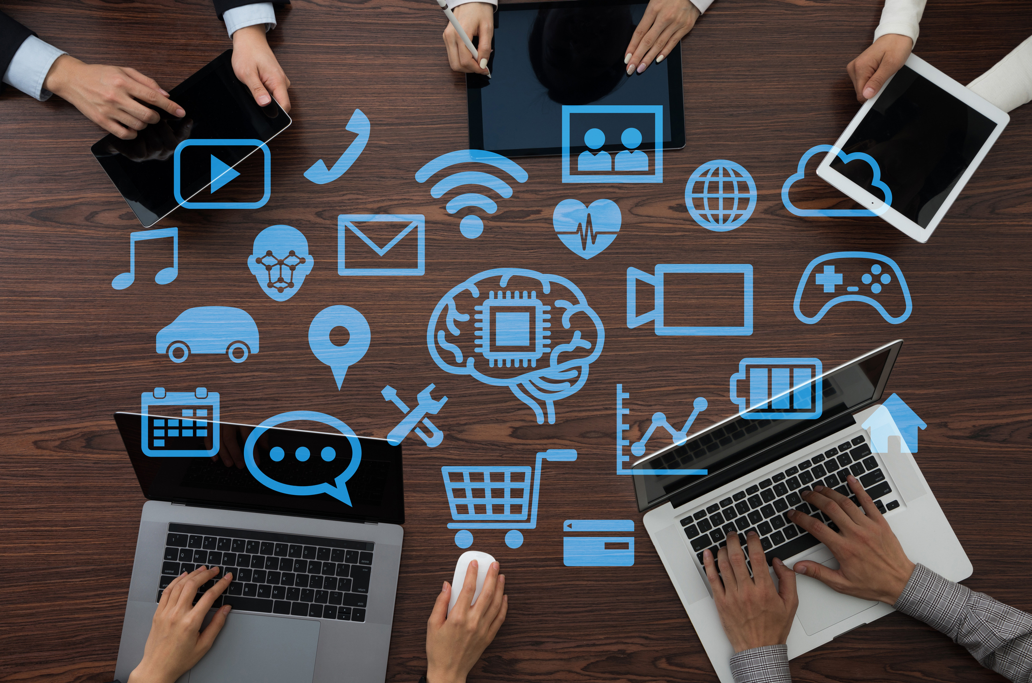 People at table with laptops, and icons for various web communication tools
