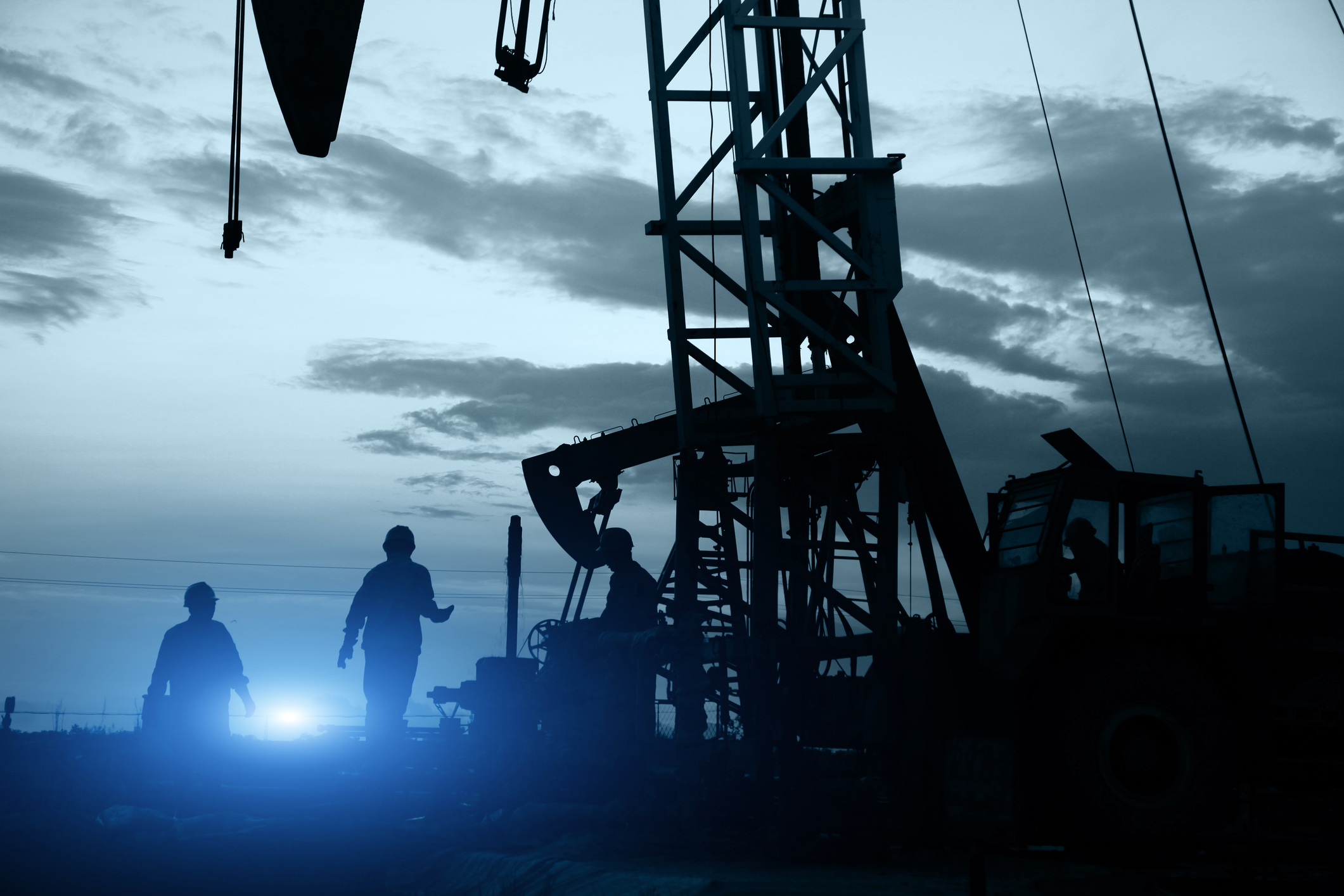 Oil workers near some oil pumps.