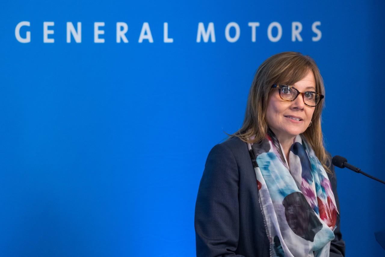 GM CEO Mary Barra stands in front of a General Motors press backfrop.