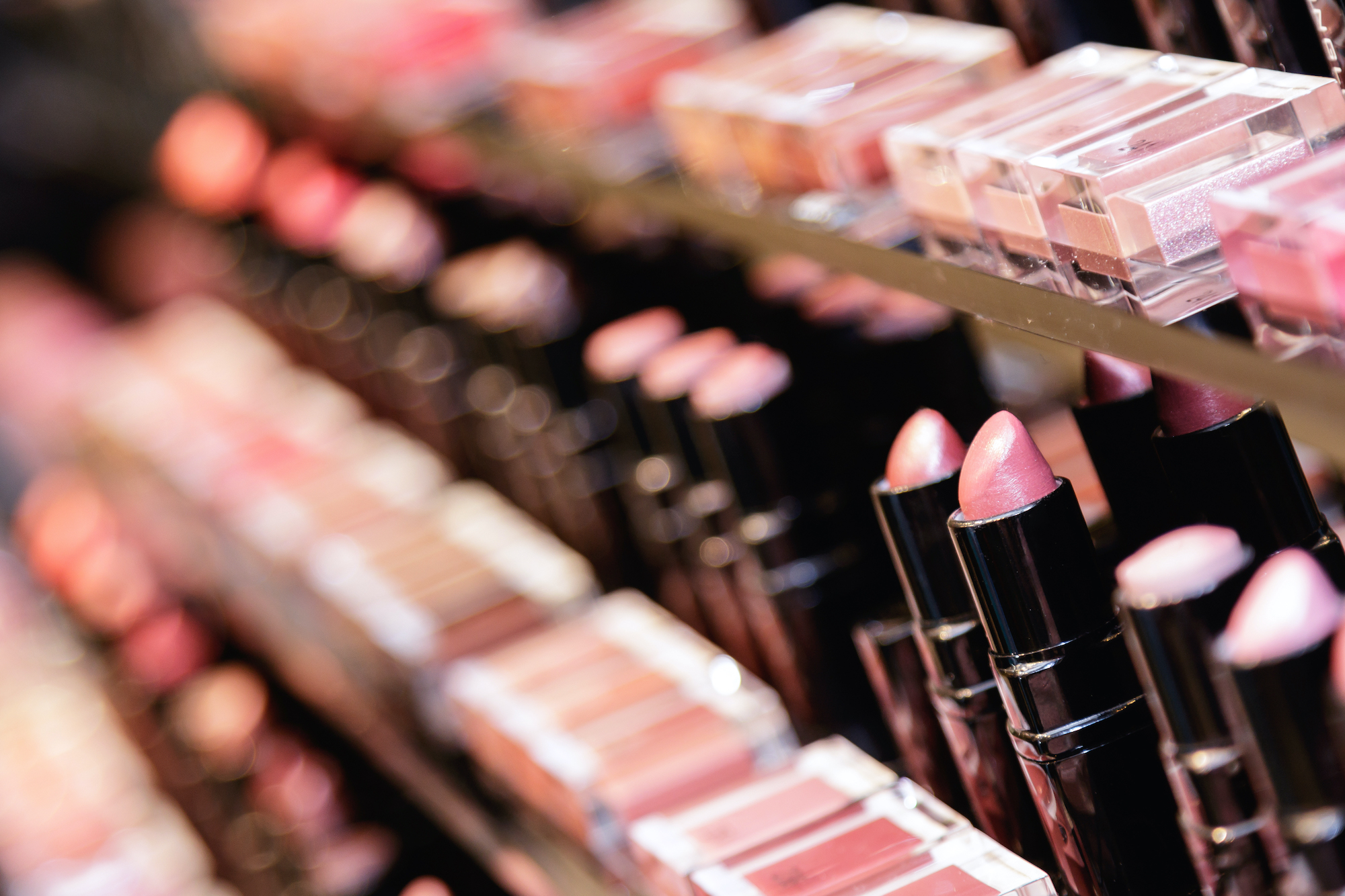 A row of lipstick and makeup testers in a beauty store.