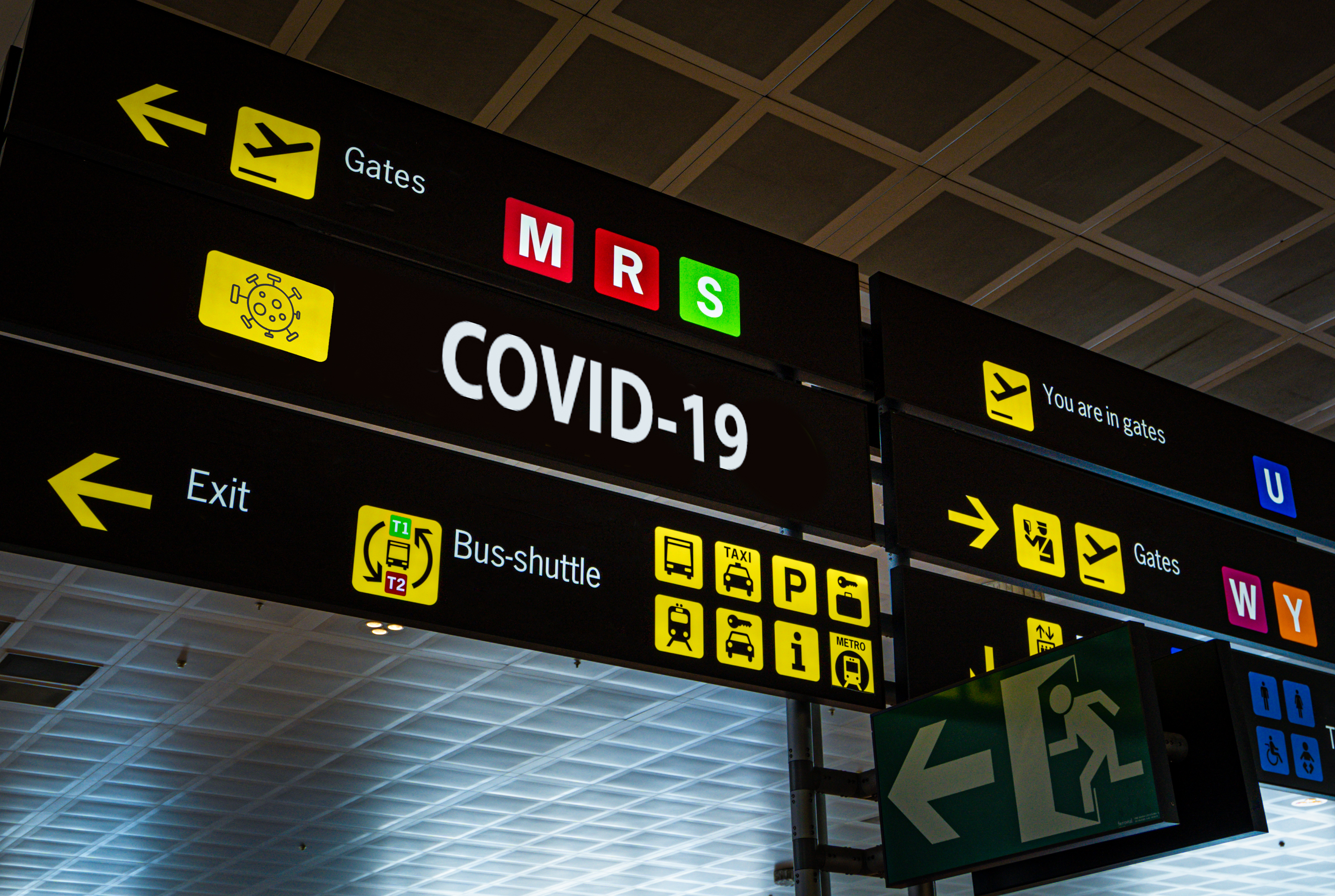 Information panel at an airport with COVID-19 on it.
