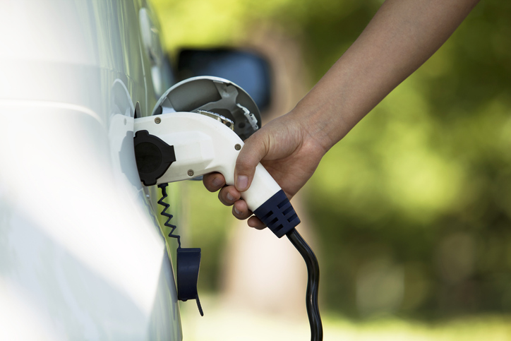 A person charging an electric car.