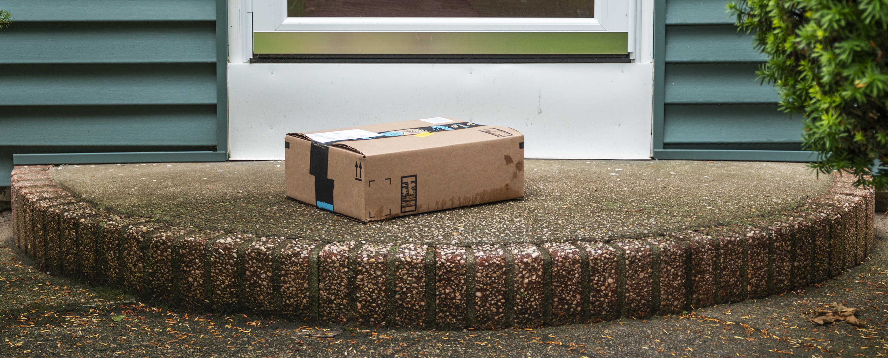 Package left on a front porch on a rainy day.