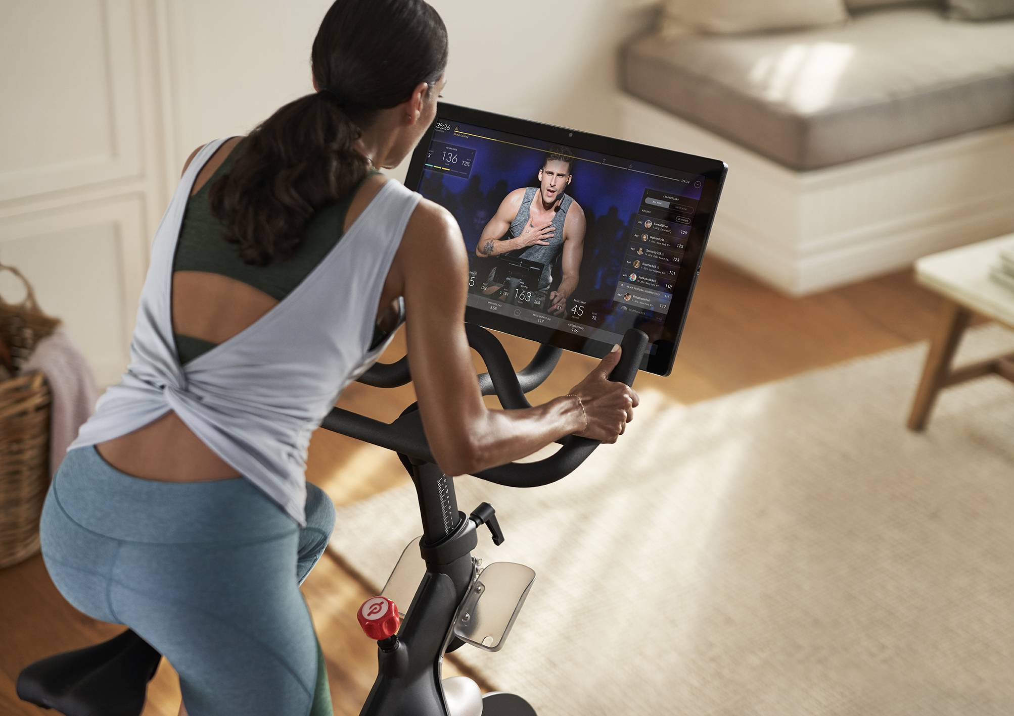 A woman working out on a Peloton cycle.