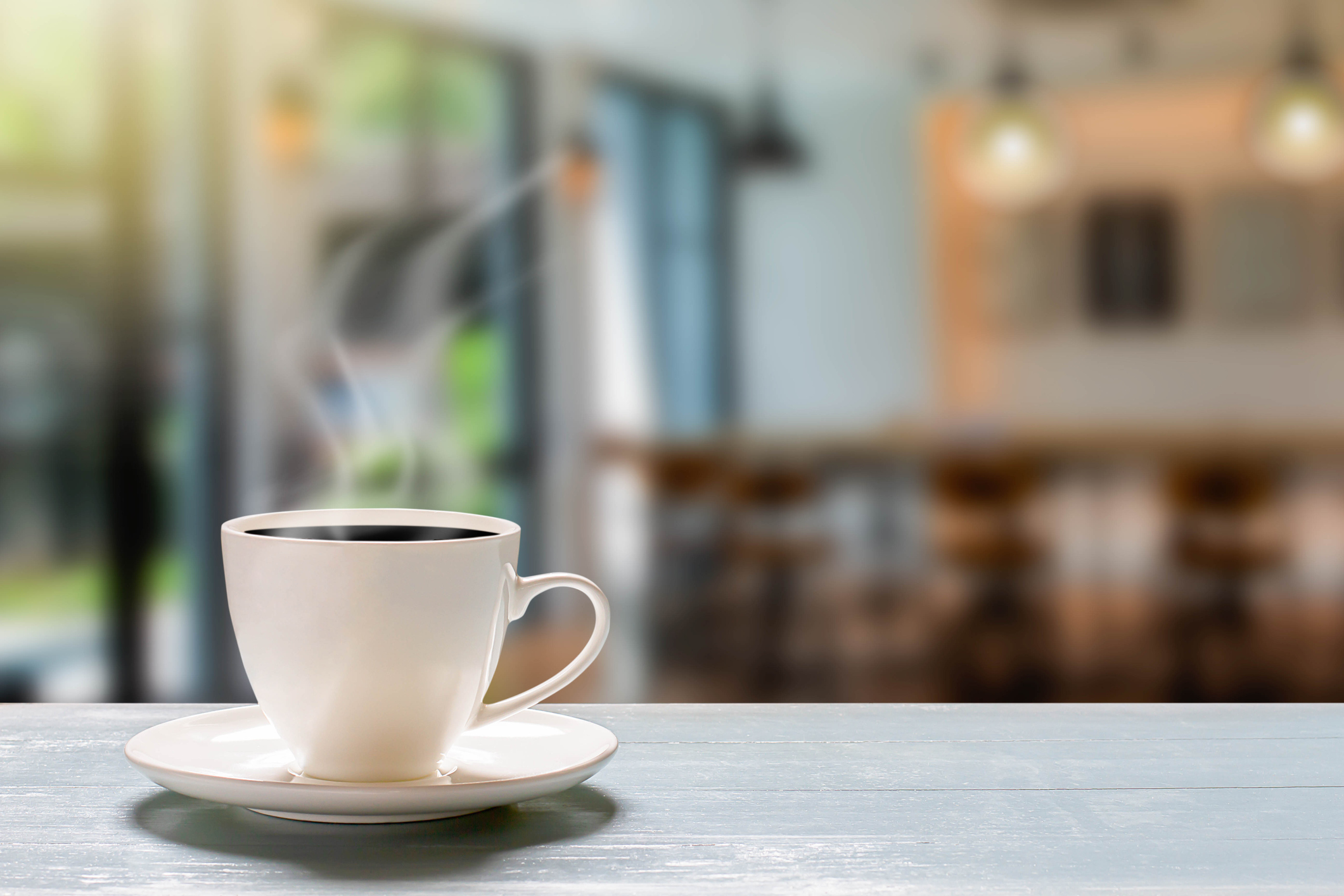 A filled coffee cup and saucer on a table