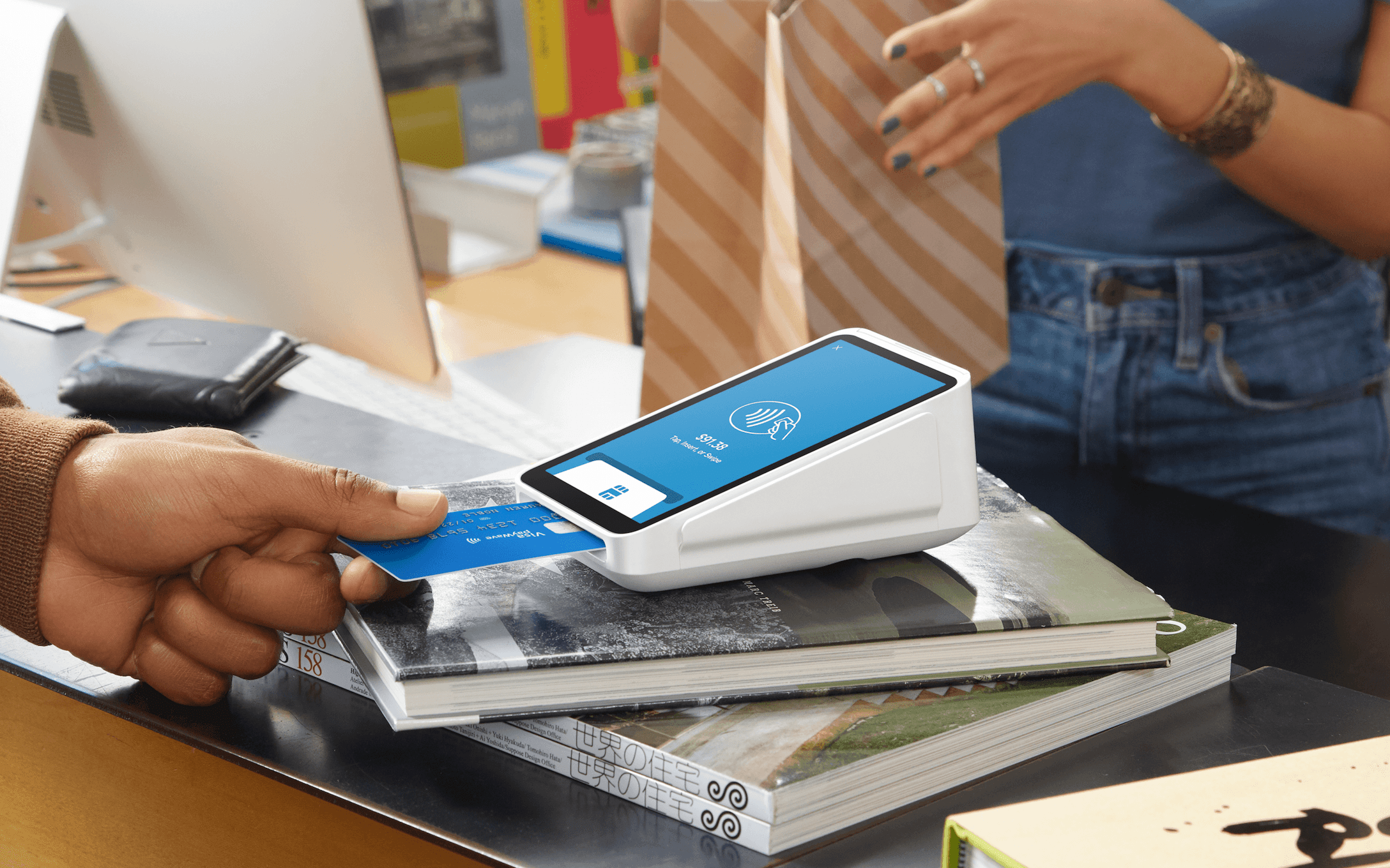 A customer inserting a credit card into a Square point-of-sale terminal.