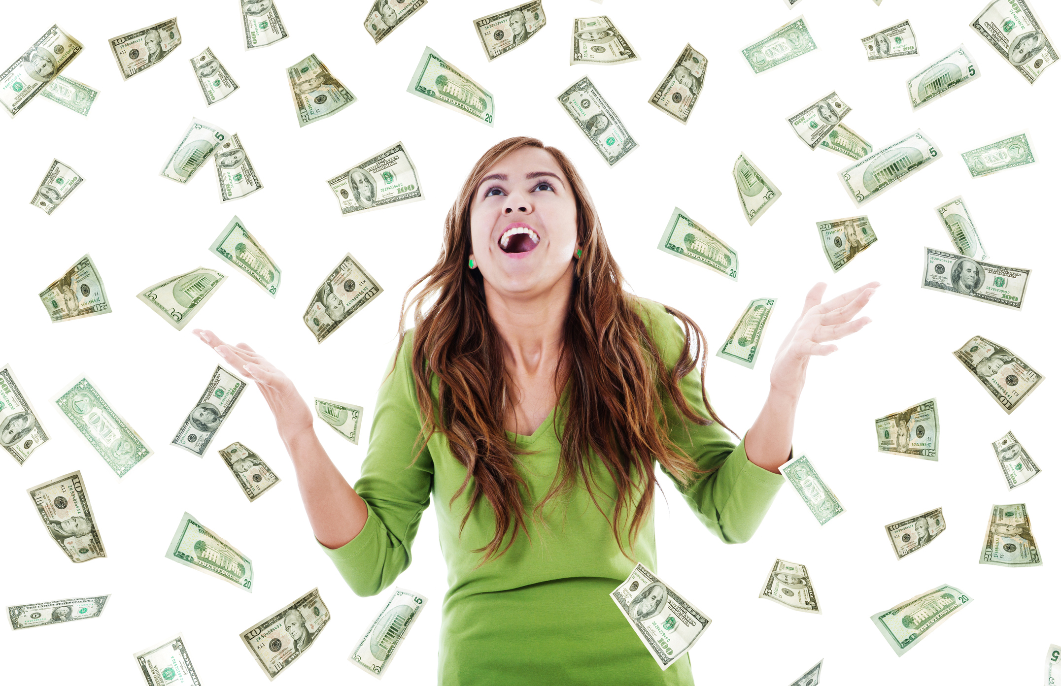 Woman smiling and holding up arms as bills float around her.
