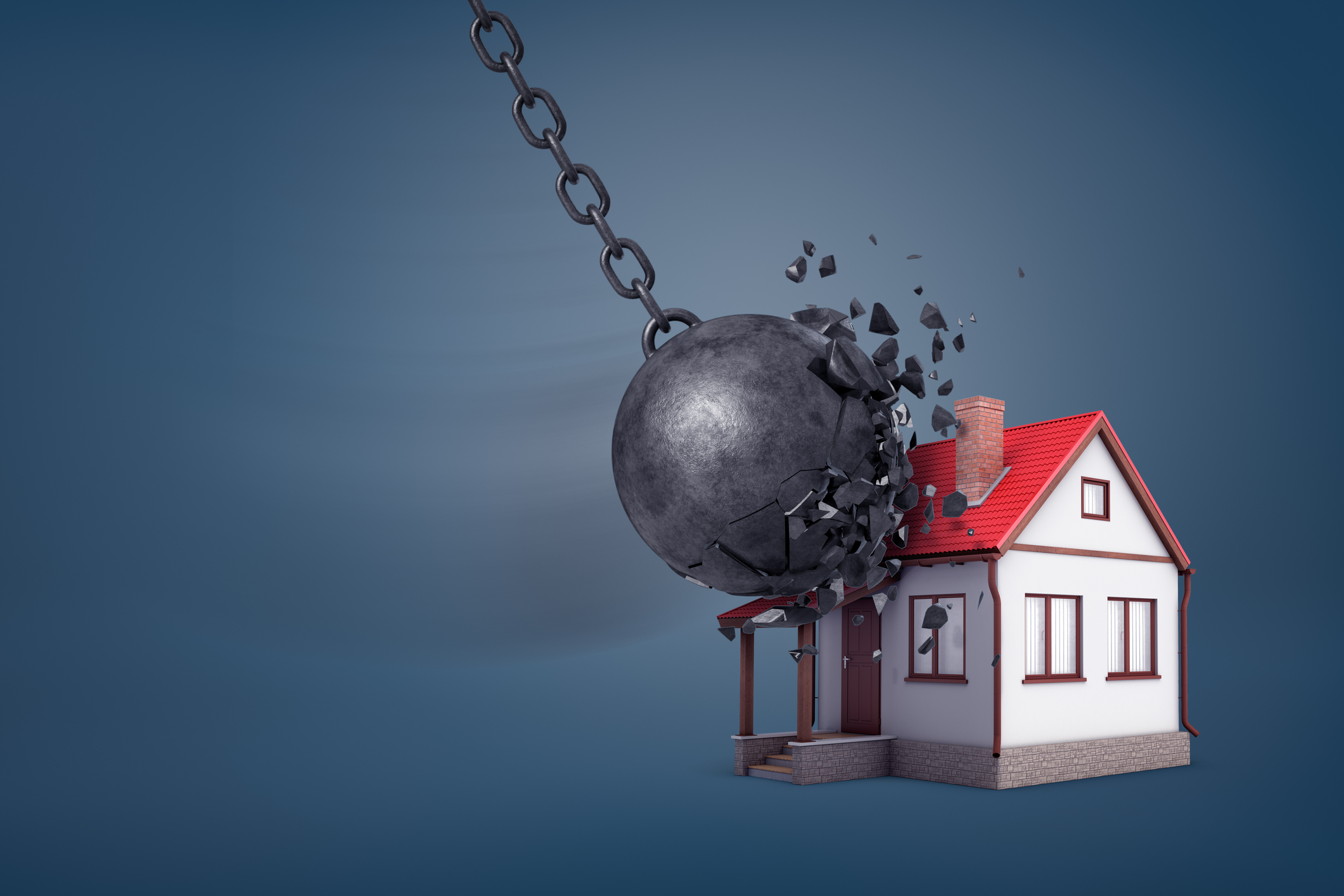 A wrecking ball hits a small house.