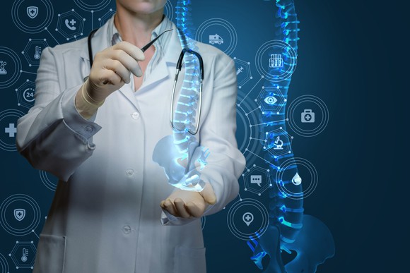 A doctor looking at an abstract hi-tech picture of a spine.