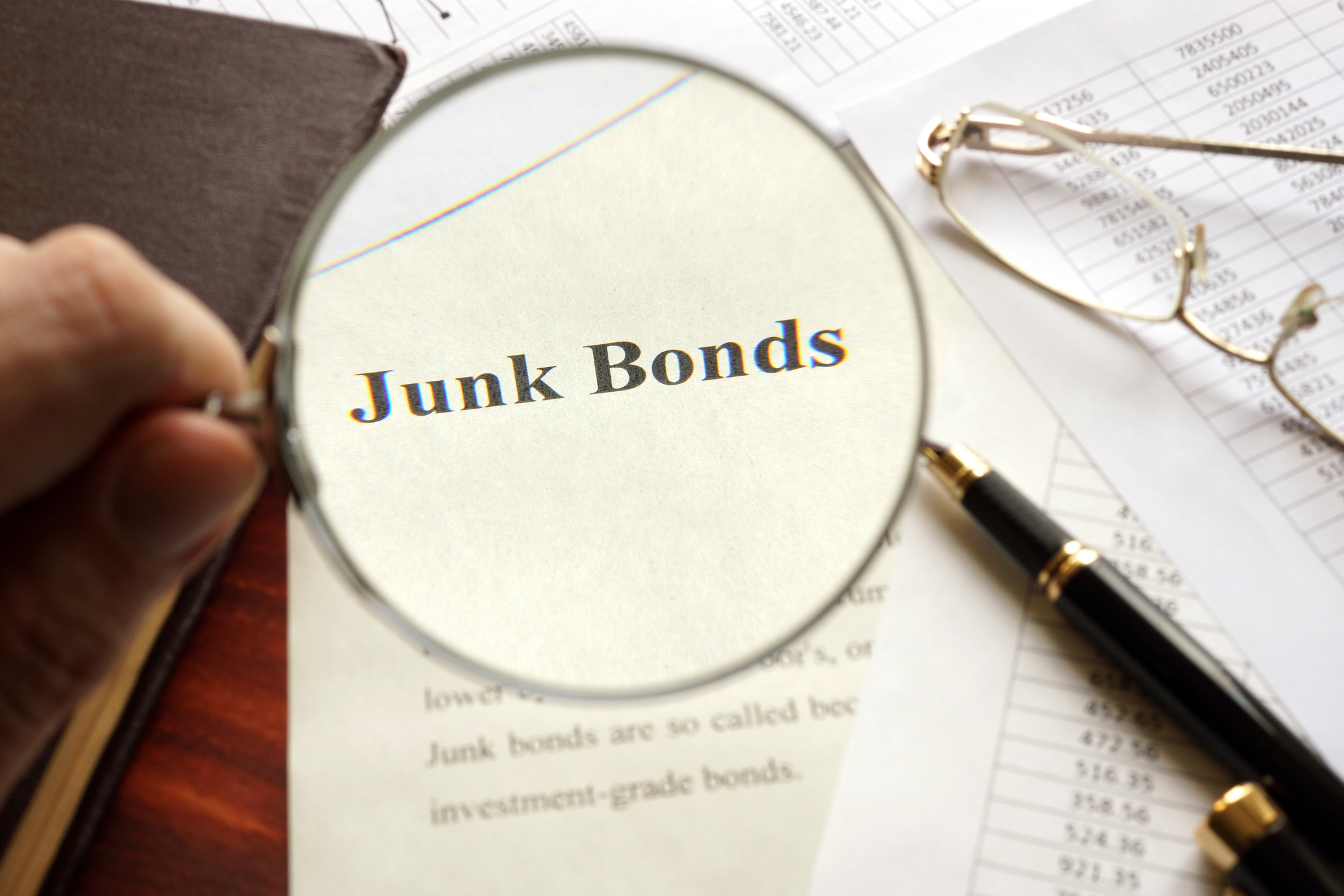 The words, "Junk Bonds" under a magnifying glass