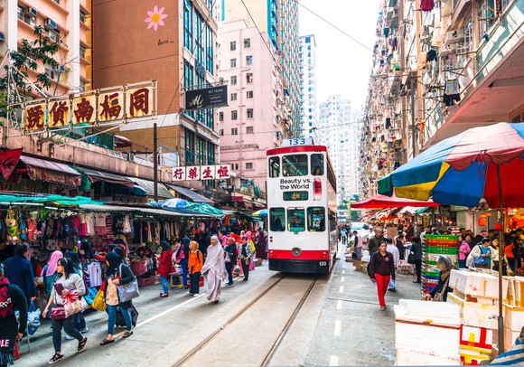 View of Hong Kong streets, with several people and a trolley