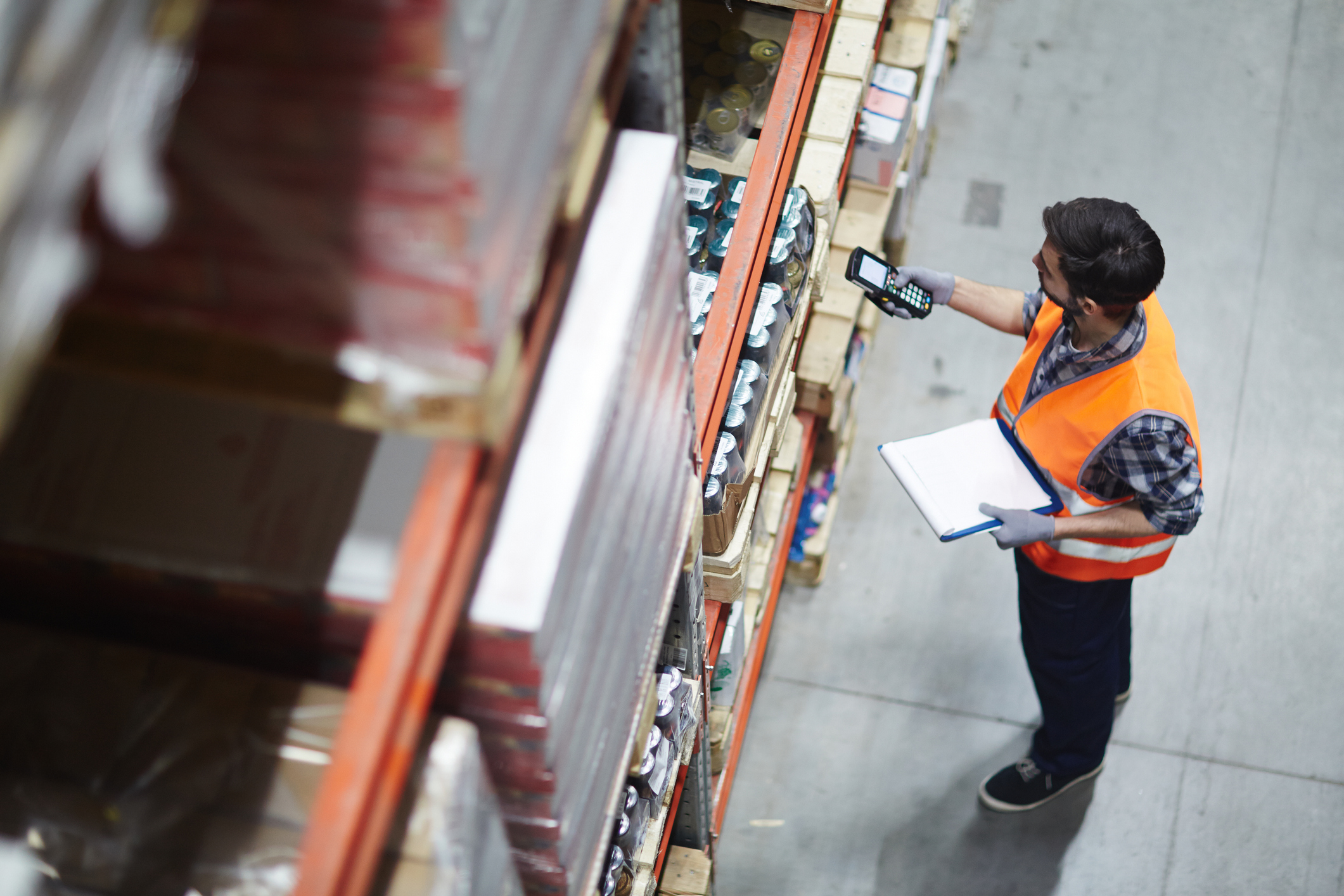 A man using a scanner in a warehouse.