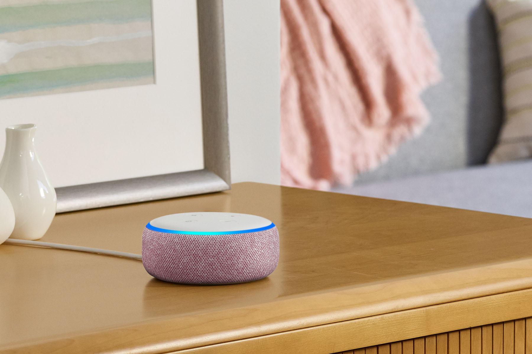 An Amazon Echo Dot on a nightstand.