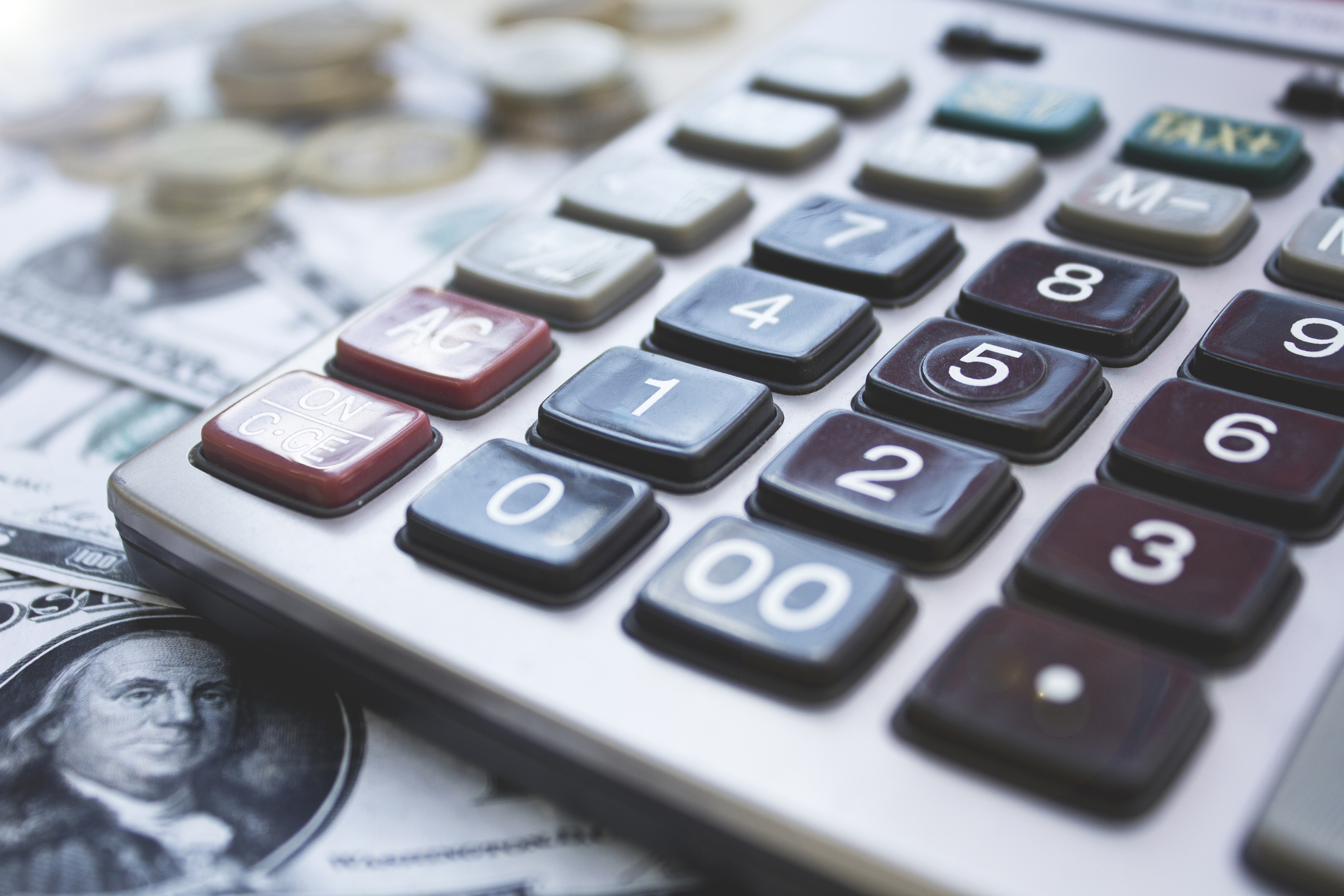 A calculator sitting on top of money