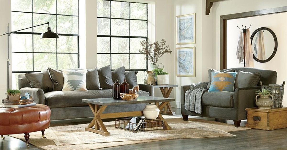 Furniture set in an open room with large windows.