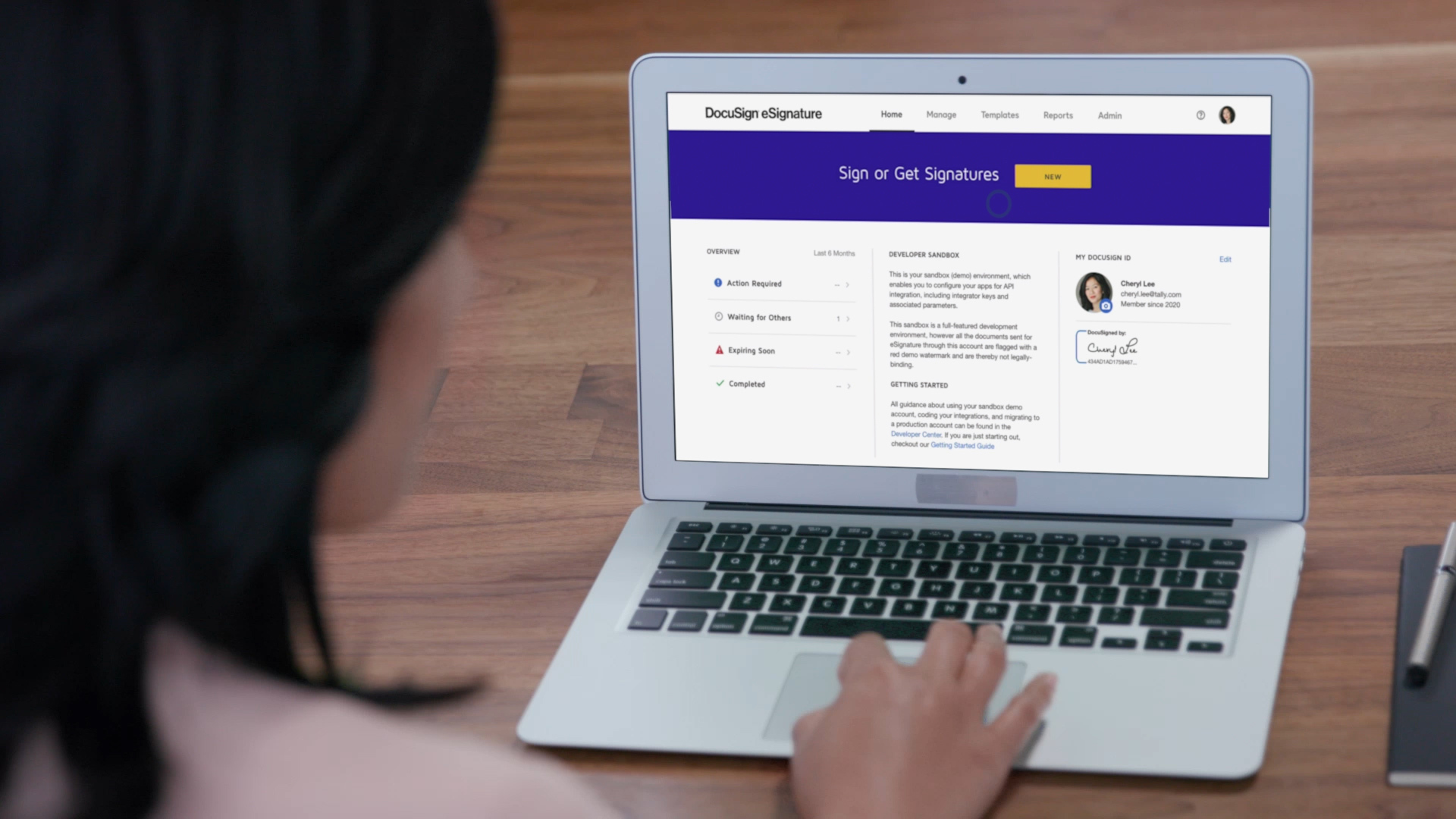 A woman on a laptop remotely signing a digital document.