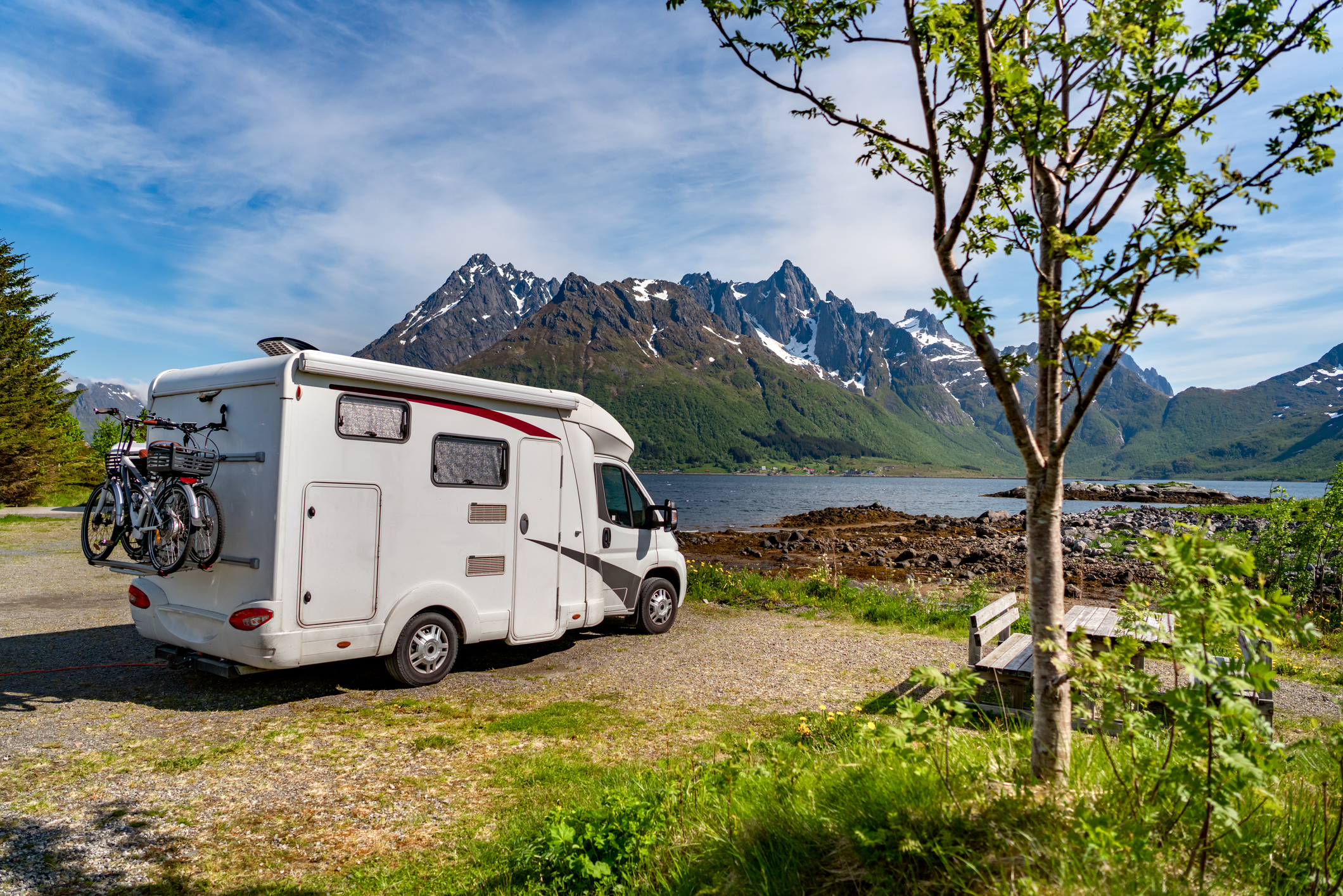 An RV parked by a lake.