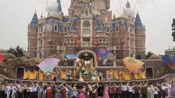 Mickey and Minnie Mouse in front of a castle at a Disney park.