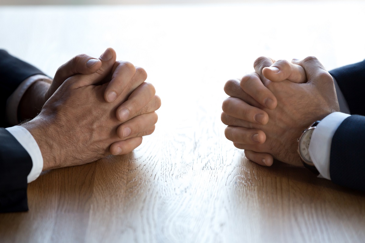 Hands on table facing one another.