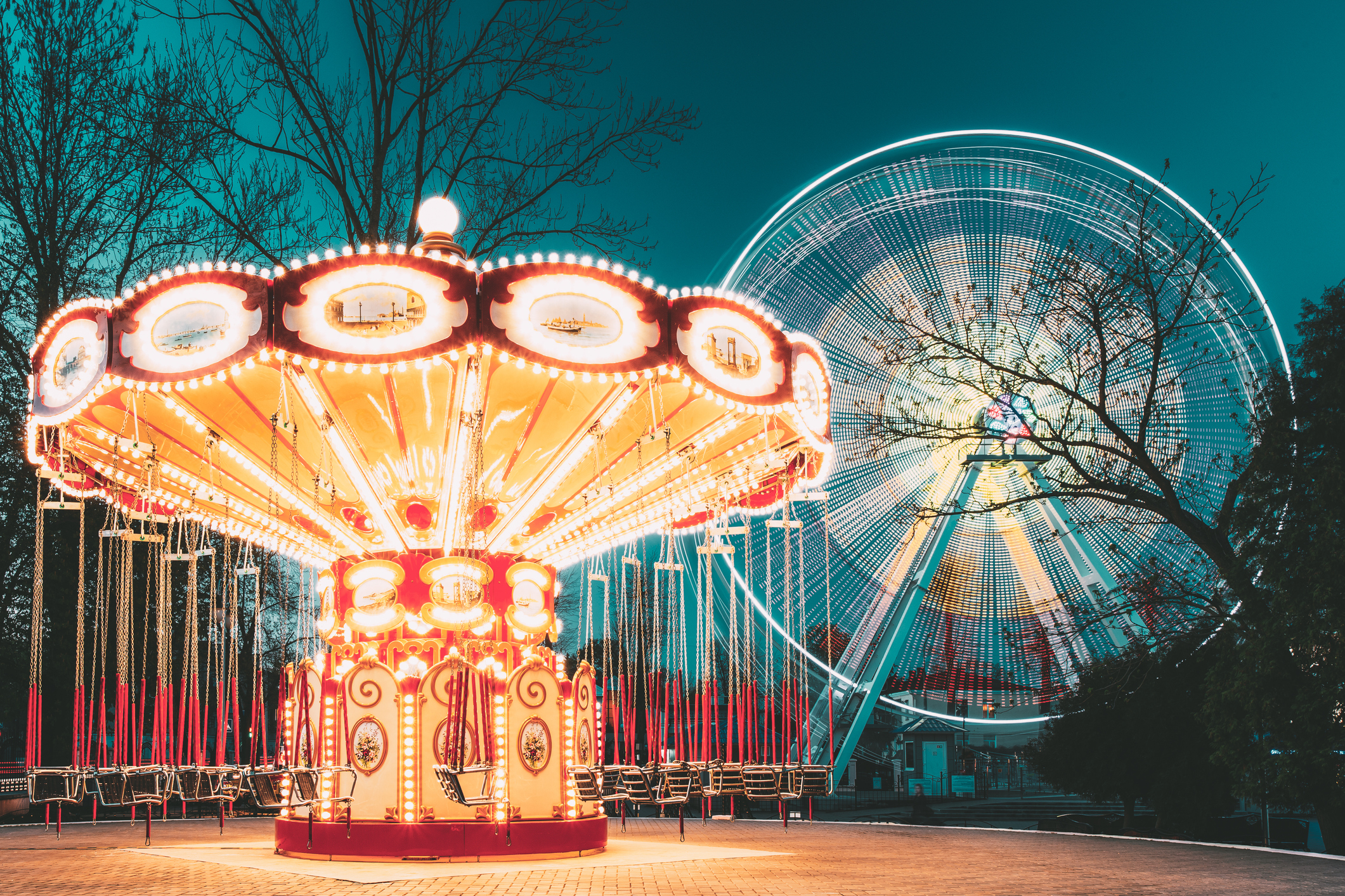 Amusement park ferris wheel and merry-go-round glow in the dark