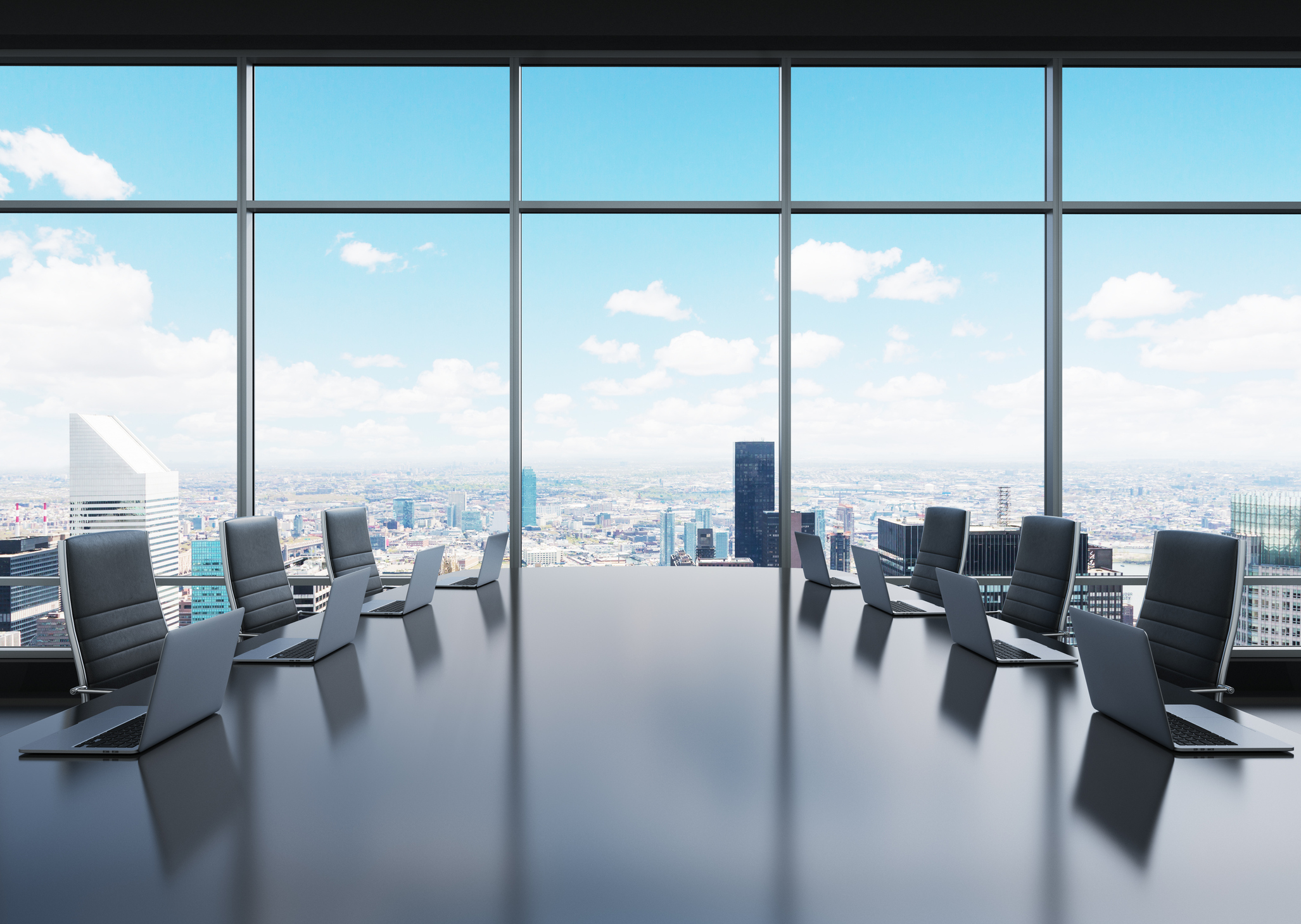 A corporate boardroom with laptops on a table