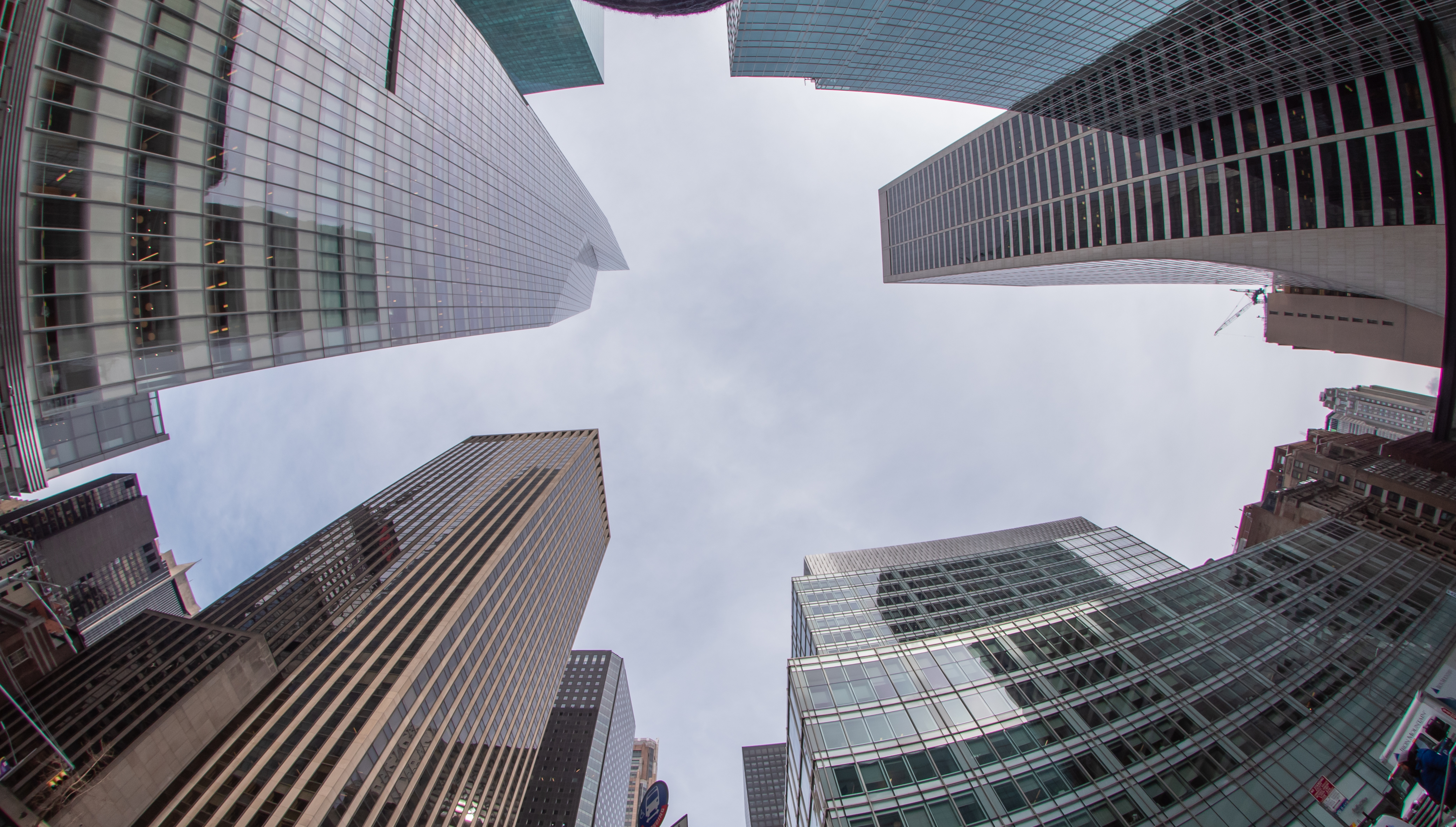 A look up at skyscrapers in New York City from the ground. One of them is the Bank of America tower.