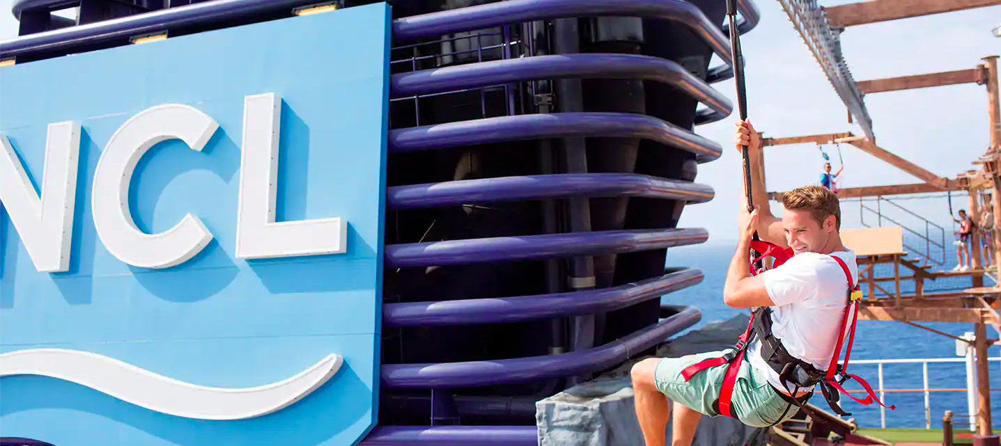 A passenger on a rock wall atop a Norwegian Cruise Line ship.