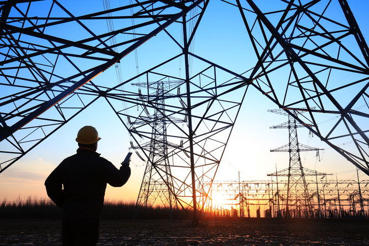 A worker observing electricity transmission infrastructure.