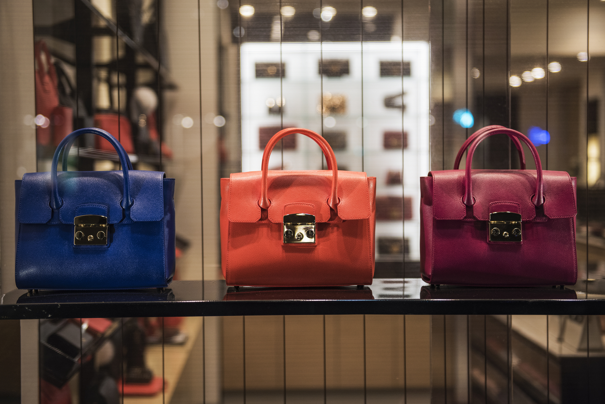 Luxury handbags displayed in a window.
