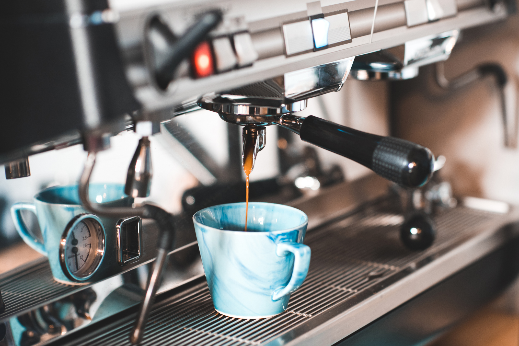 Coffee machine pouring coffee into a blue cup.