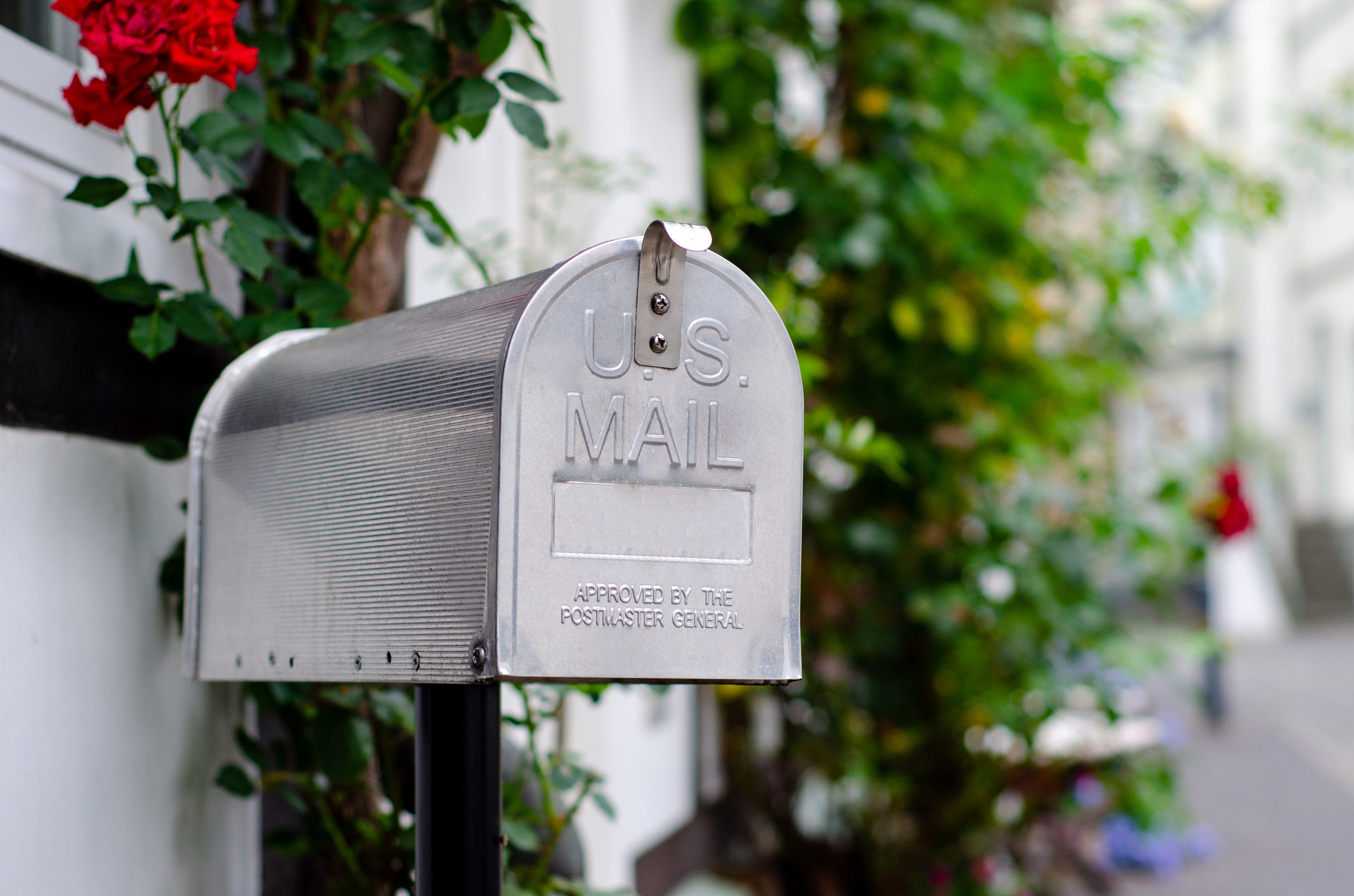 A silver mailbox on a street.