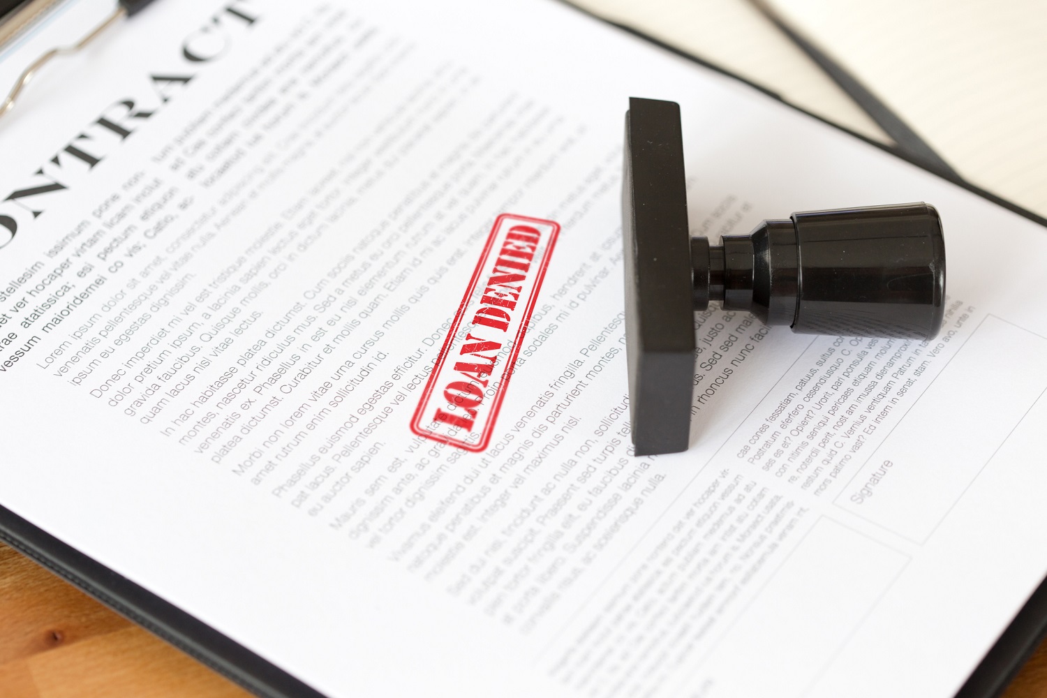 Loan contract with denied stamped on it.