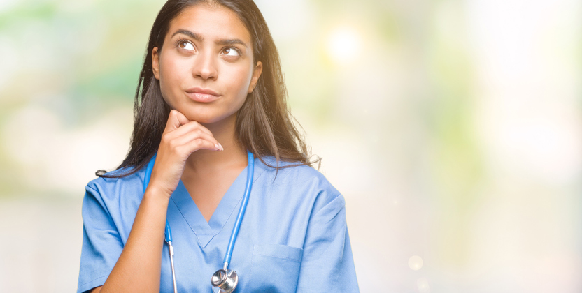 Nurse with her hand on her chin and a thoughtful expression on her face.