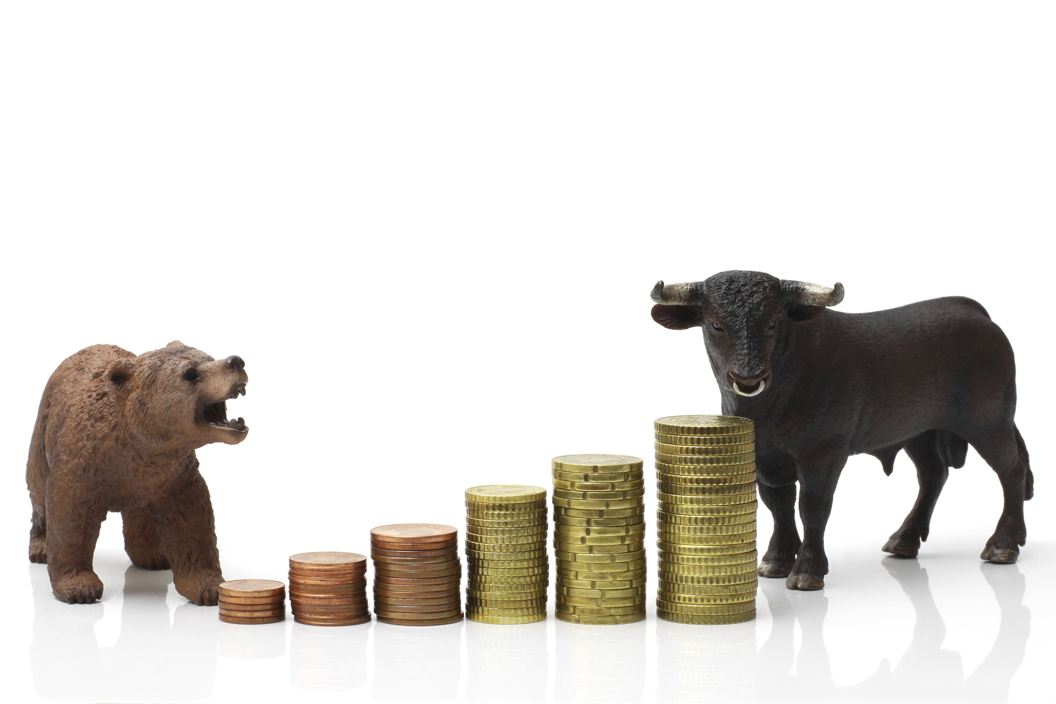 Bear and bull standing near a growing stack of coins