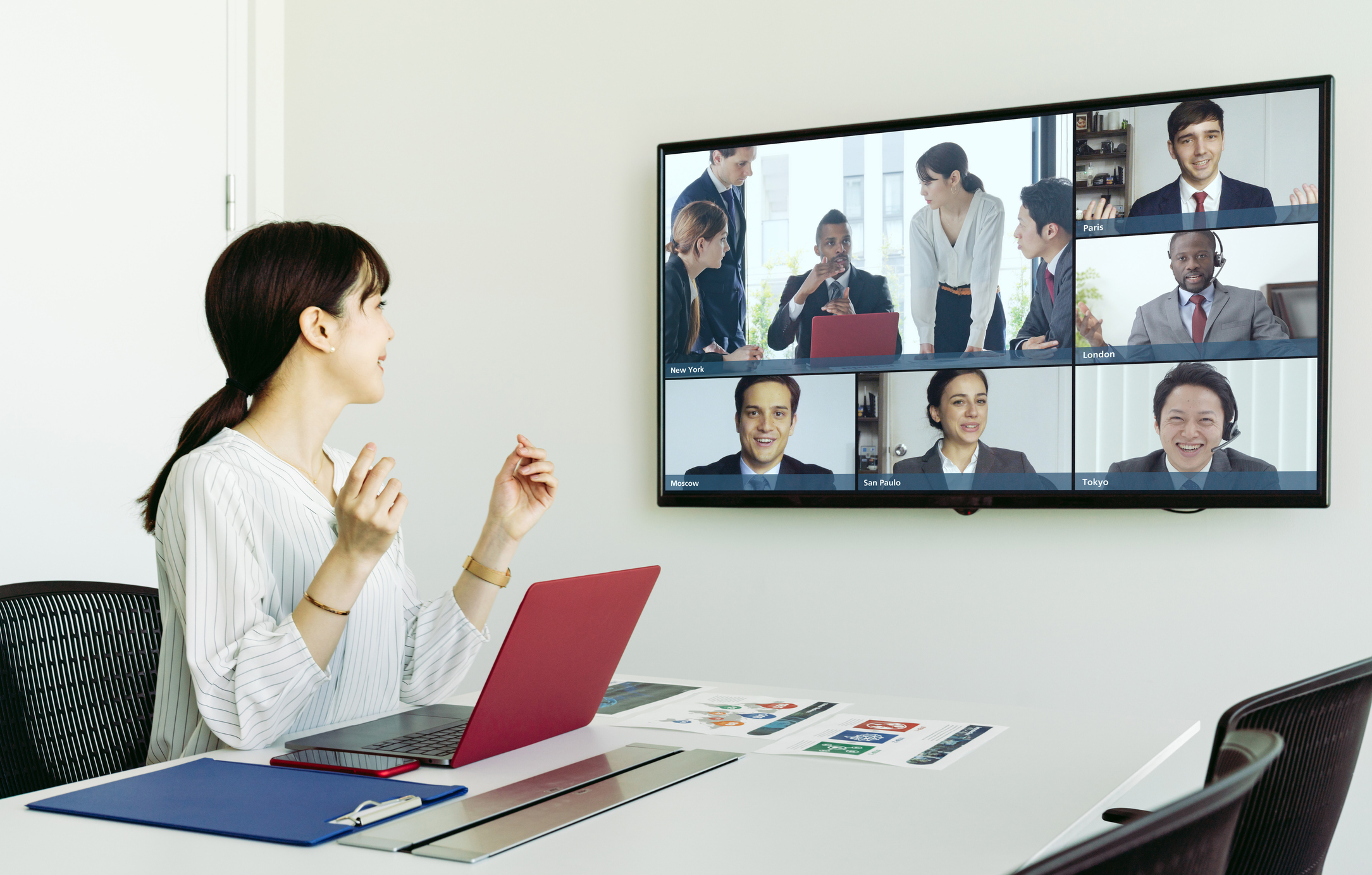 A person at a conference table leads a videoconference.