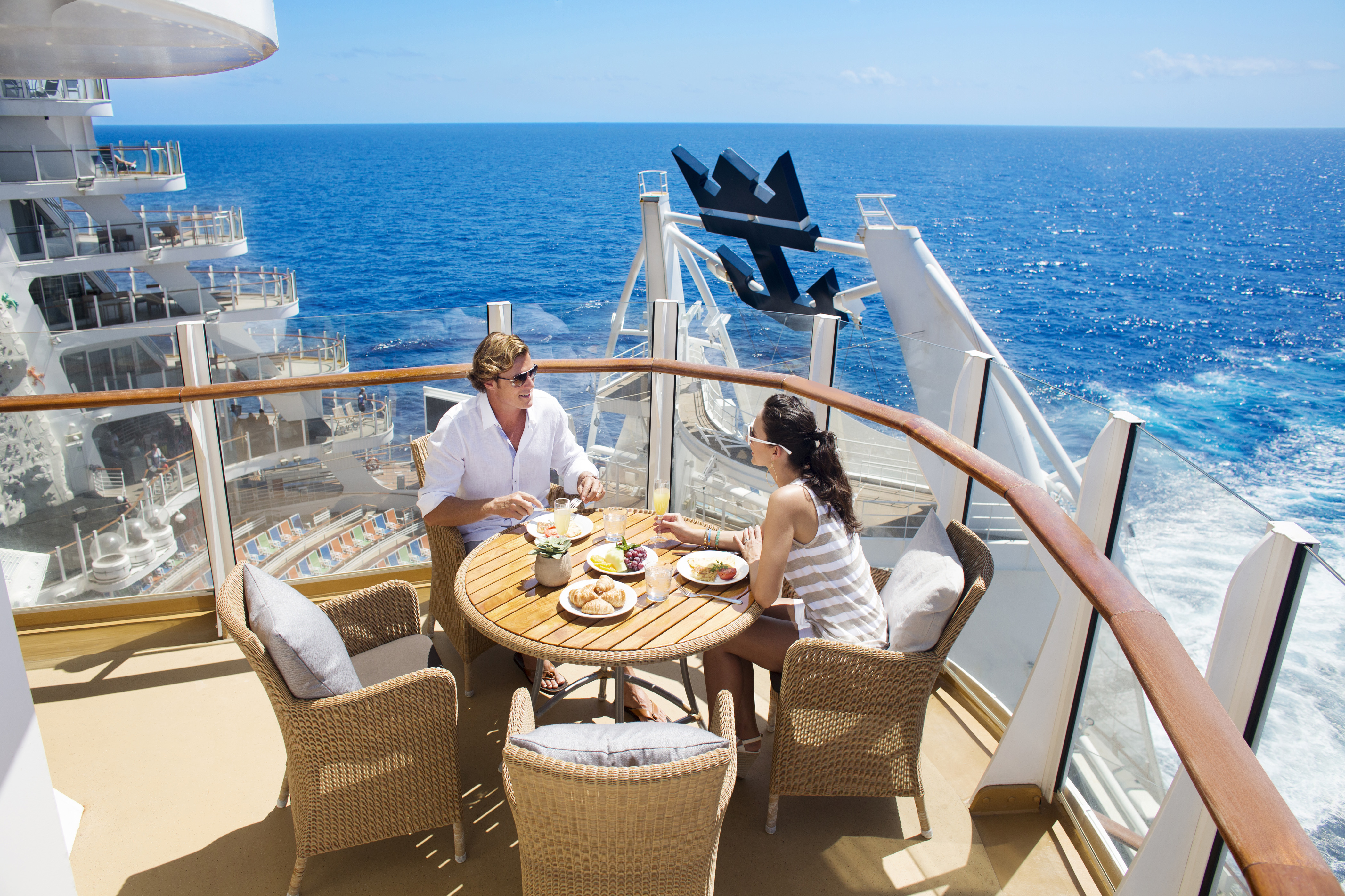 A couple enjoying breakfast on the upper deck of a Royal Caribbean ship.