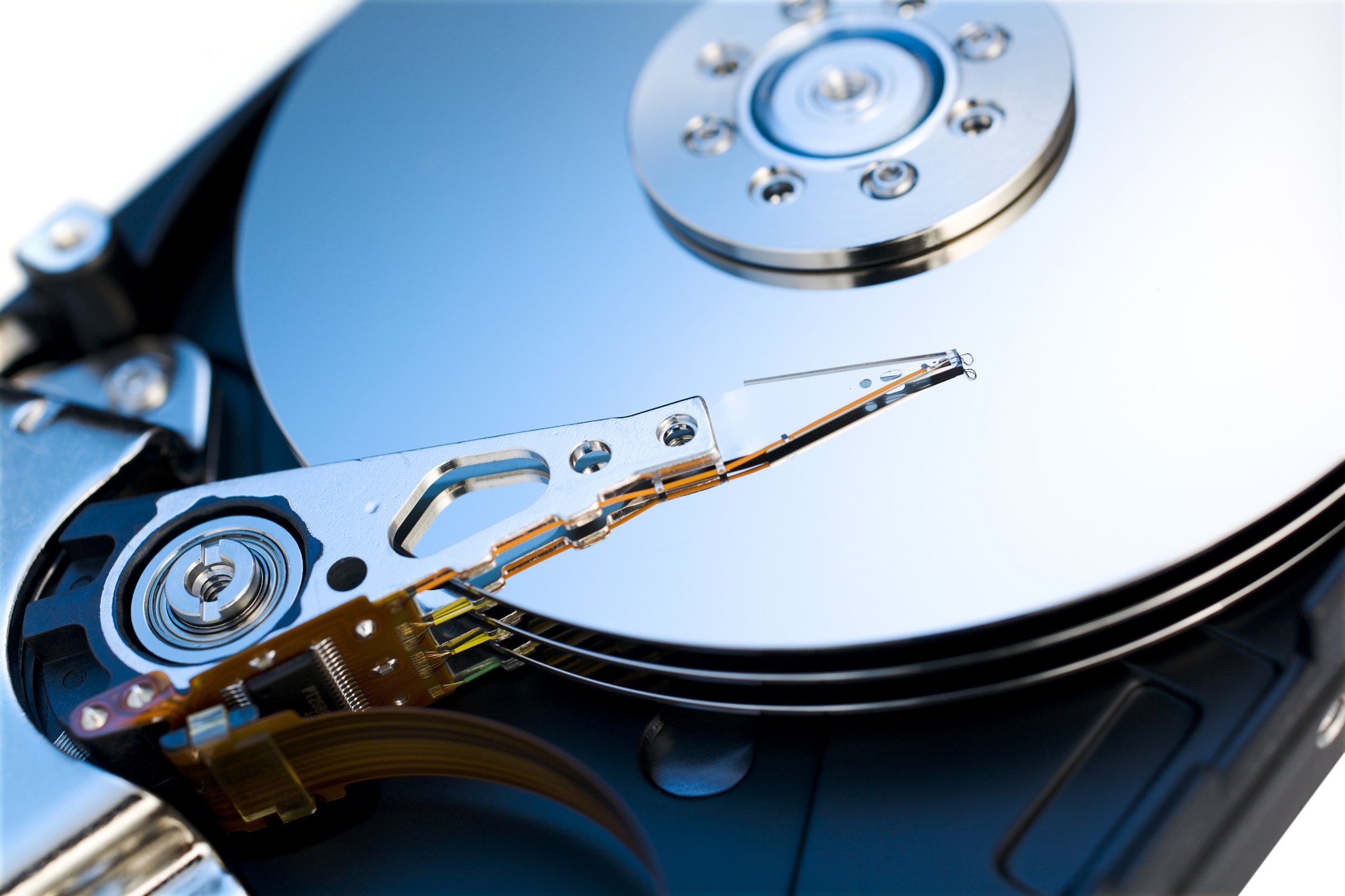 Photo of a traditional three-platter hard drive with the cover opened up.