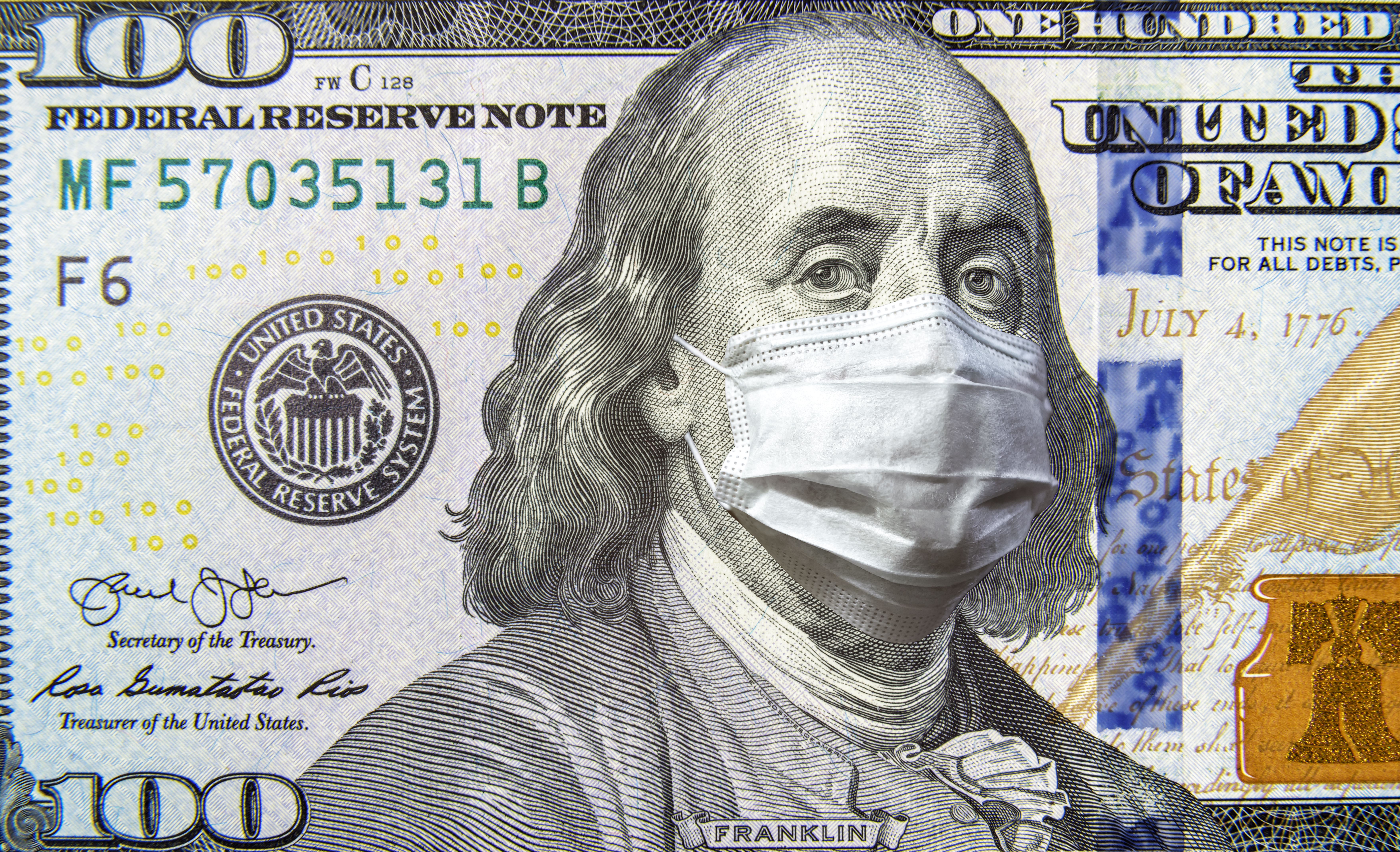 A $100 bill with Benjamin Franklin wearing a surgical mask