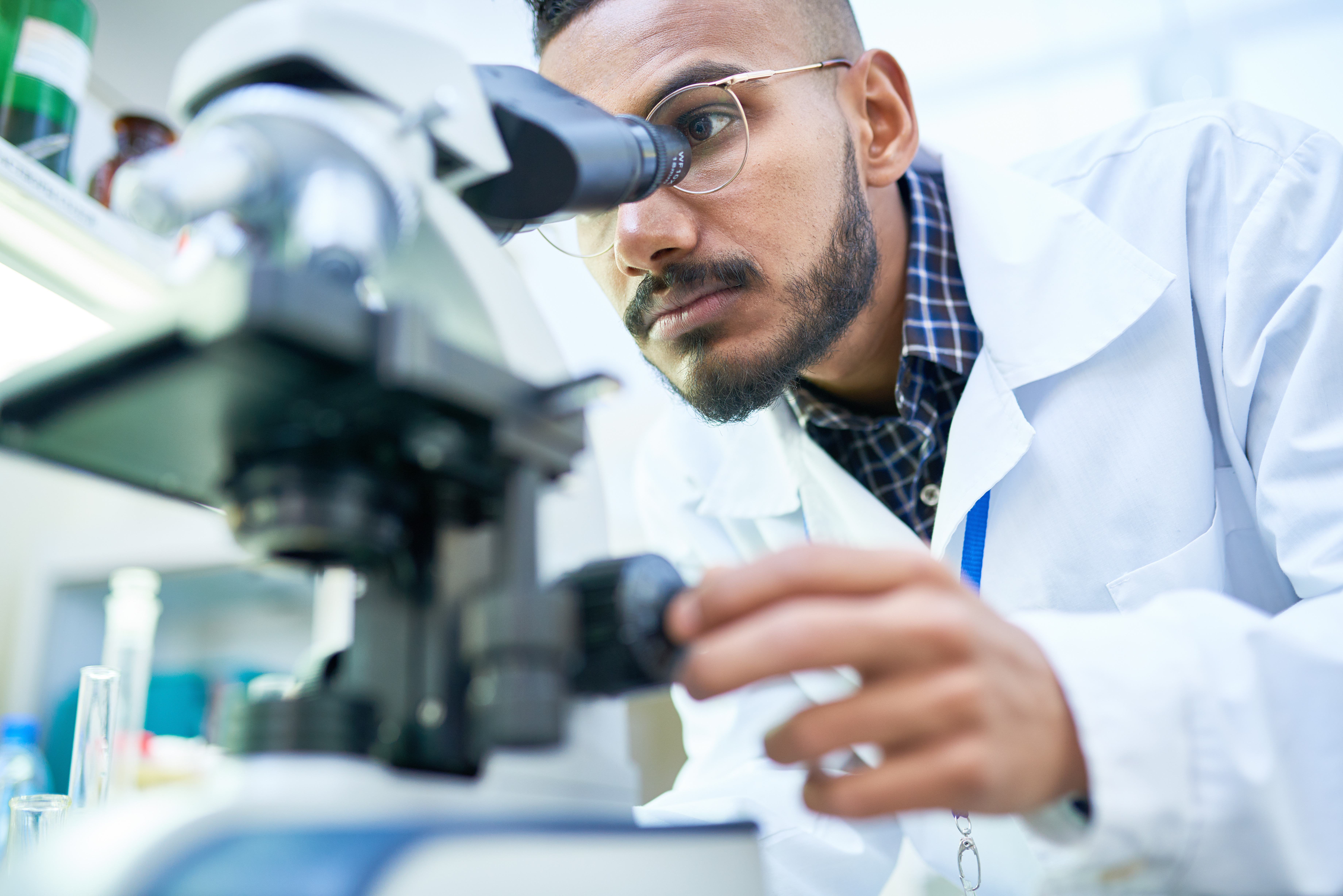 A man looks into a microcope